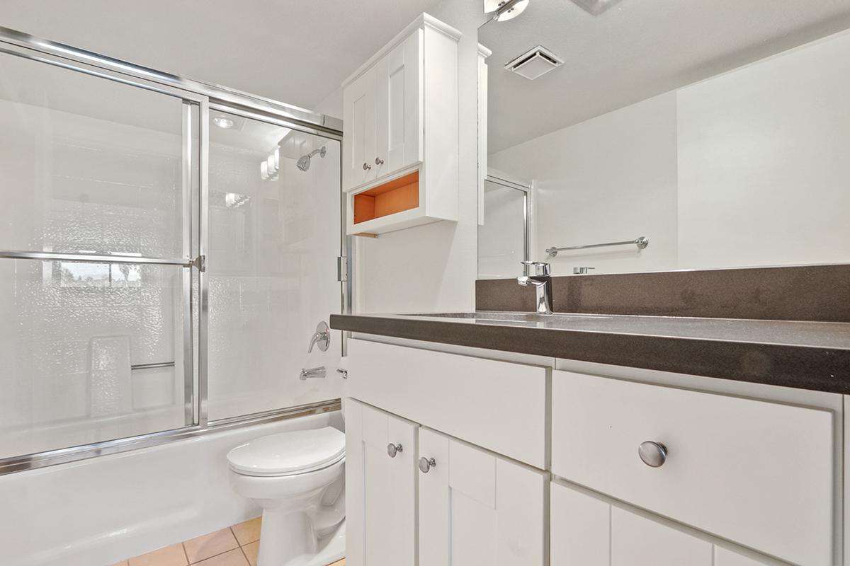 a white sink sitting next to a shower