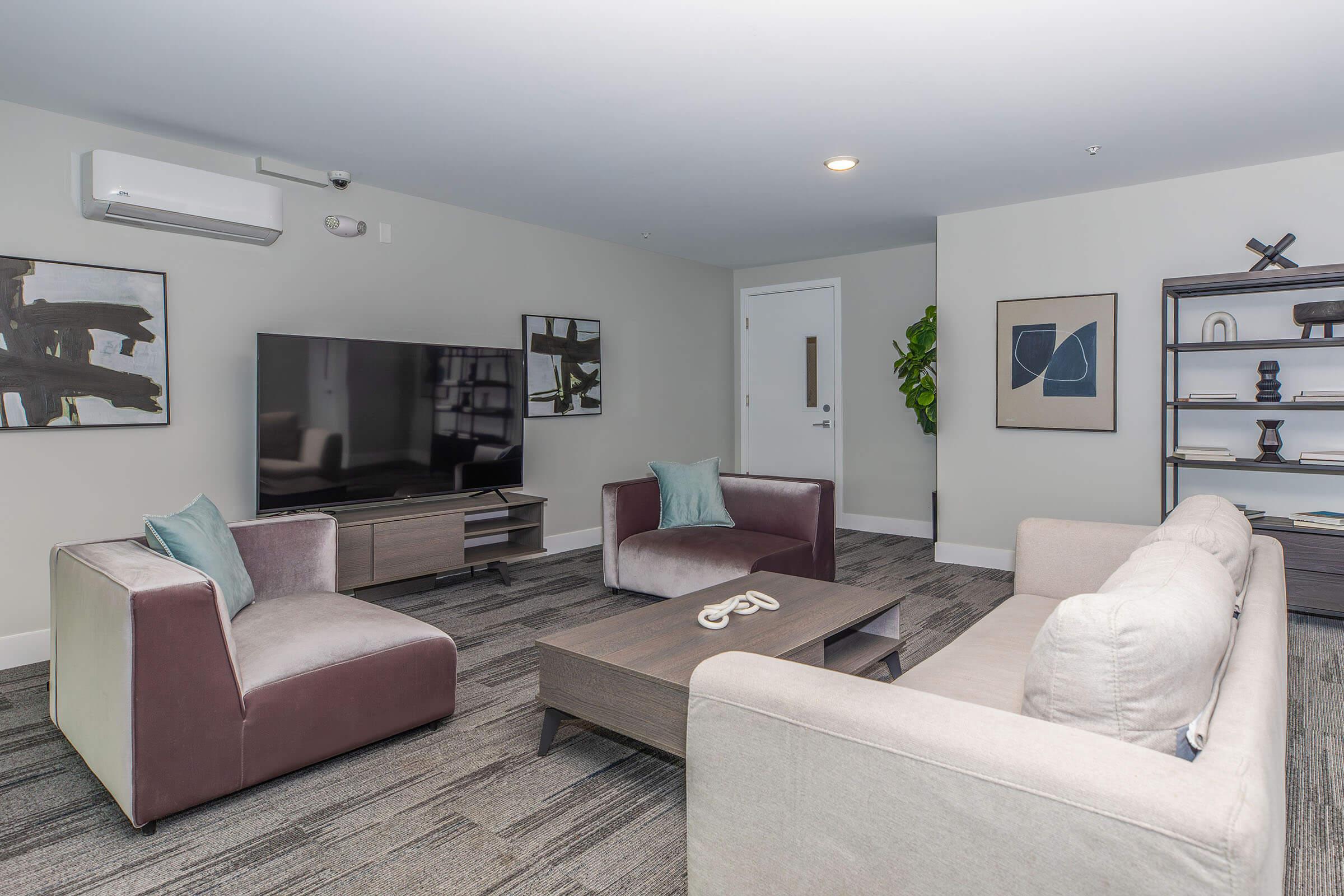 a living room filled with furniture and a flat screen tv