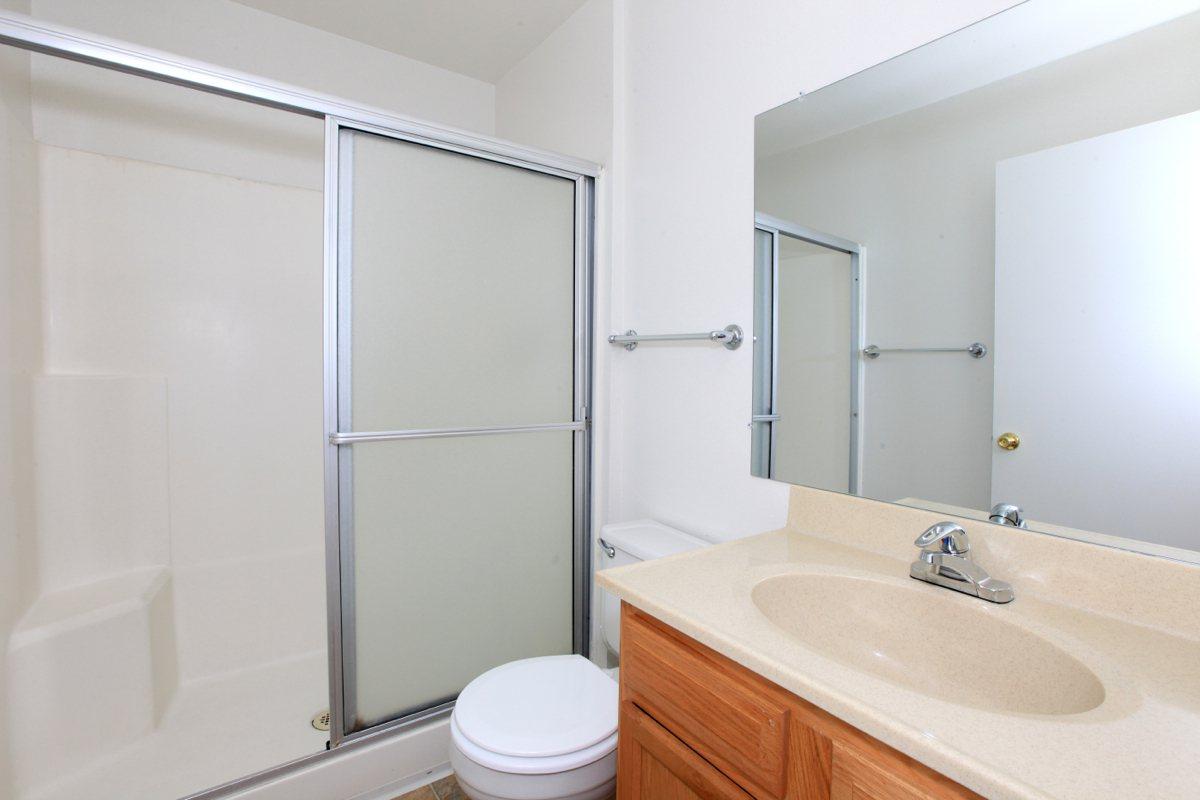 a white sink sitting next to a glass shower door