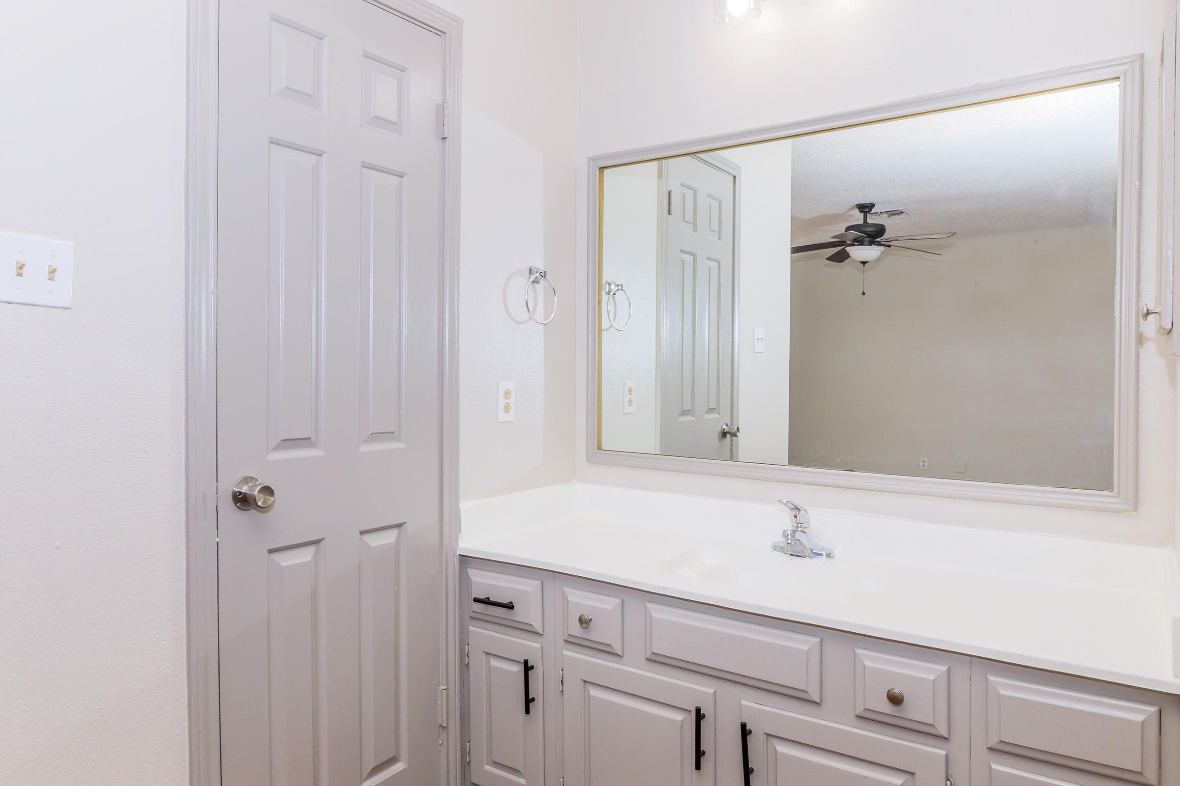 a kitchen with a sink and a mirror