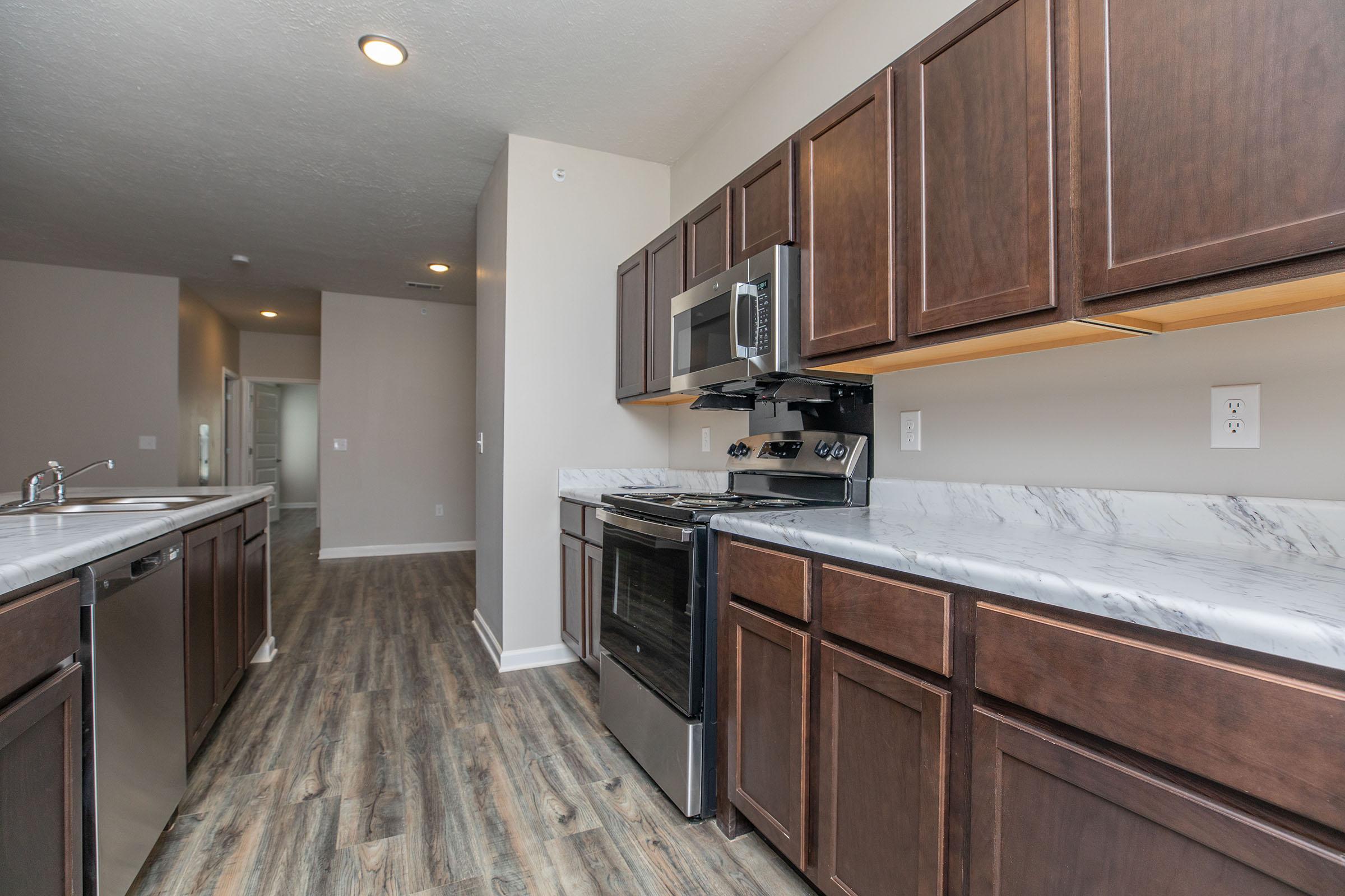 a large kitchen with stainless steel appliances and wooden cabinets