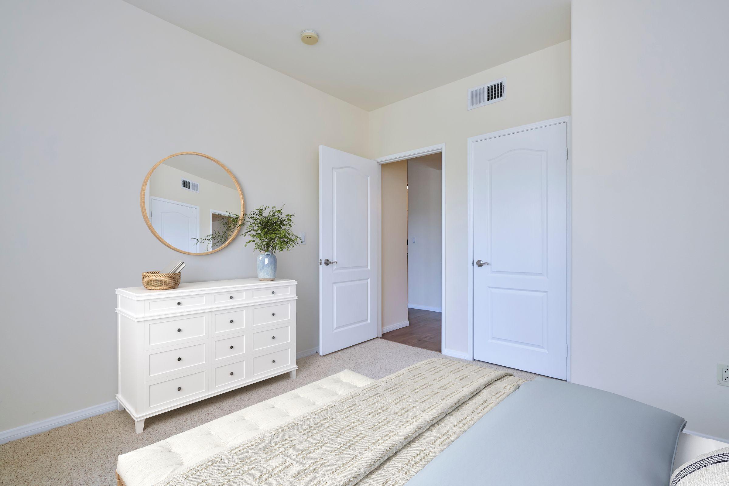 a bedroom with a white dresser