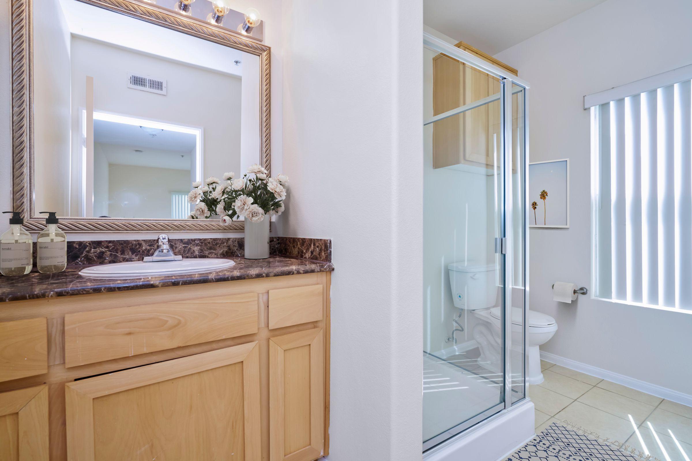 a furnished bathroom with glass shower doors