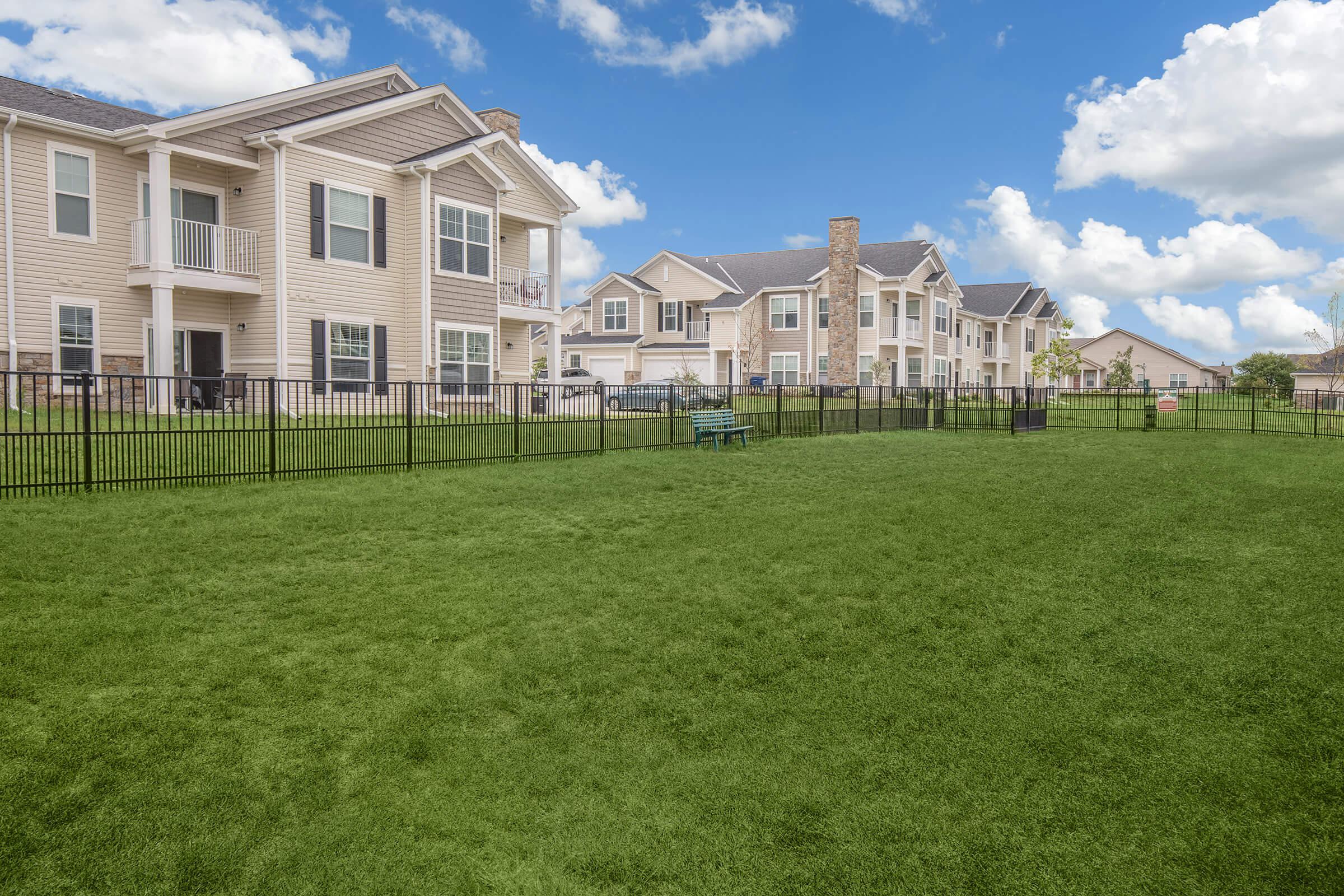 a large green field in front of a building