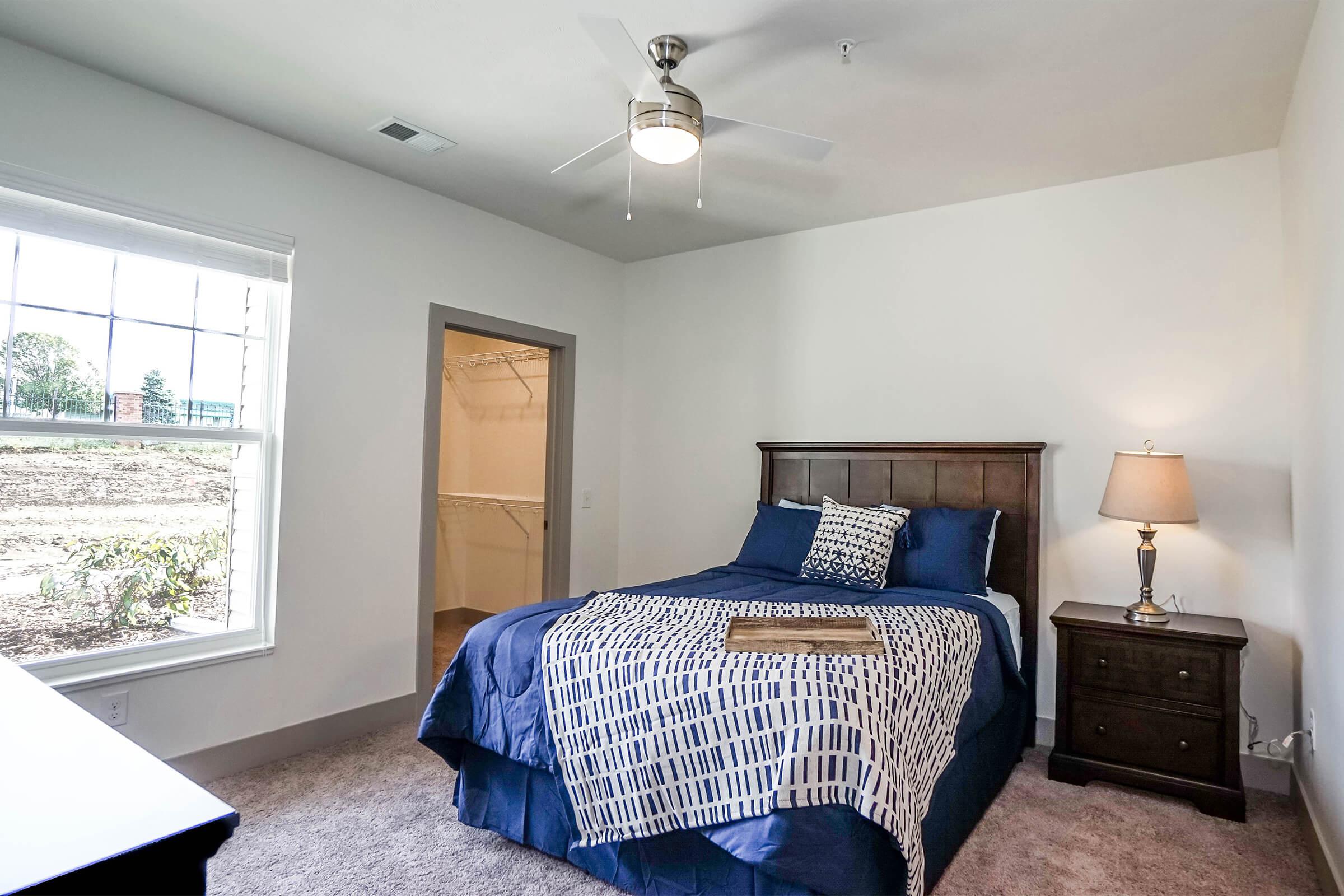 a bedroom with a bed and desk in a room