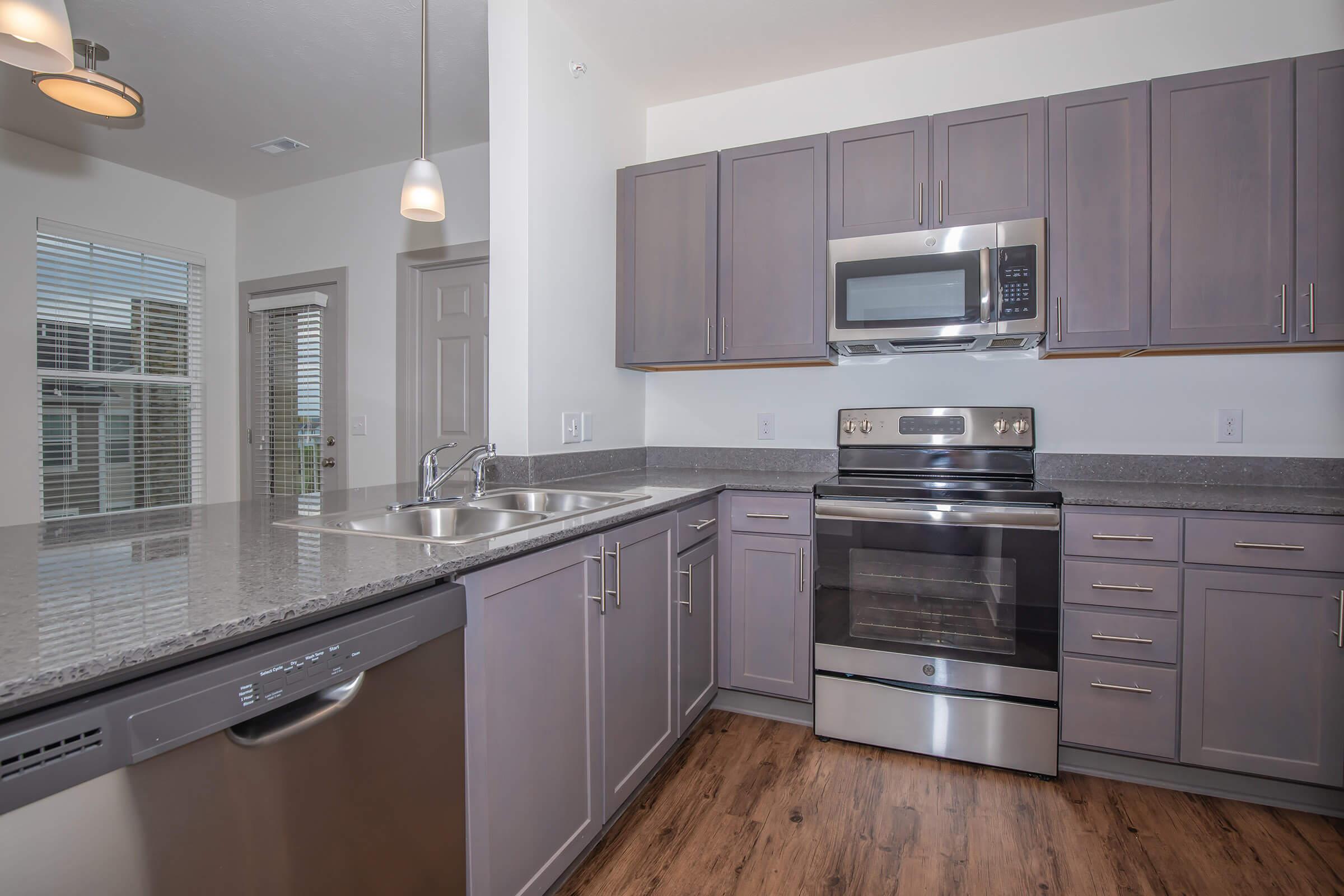 a large kitchen with stainless steel appliances and wooden cabinets