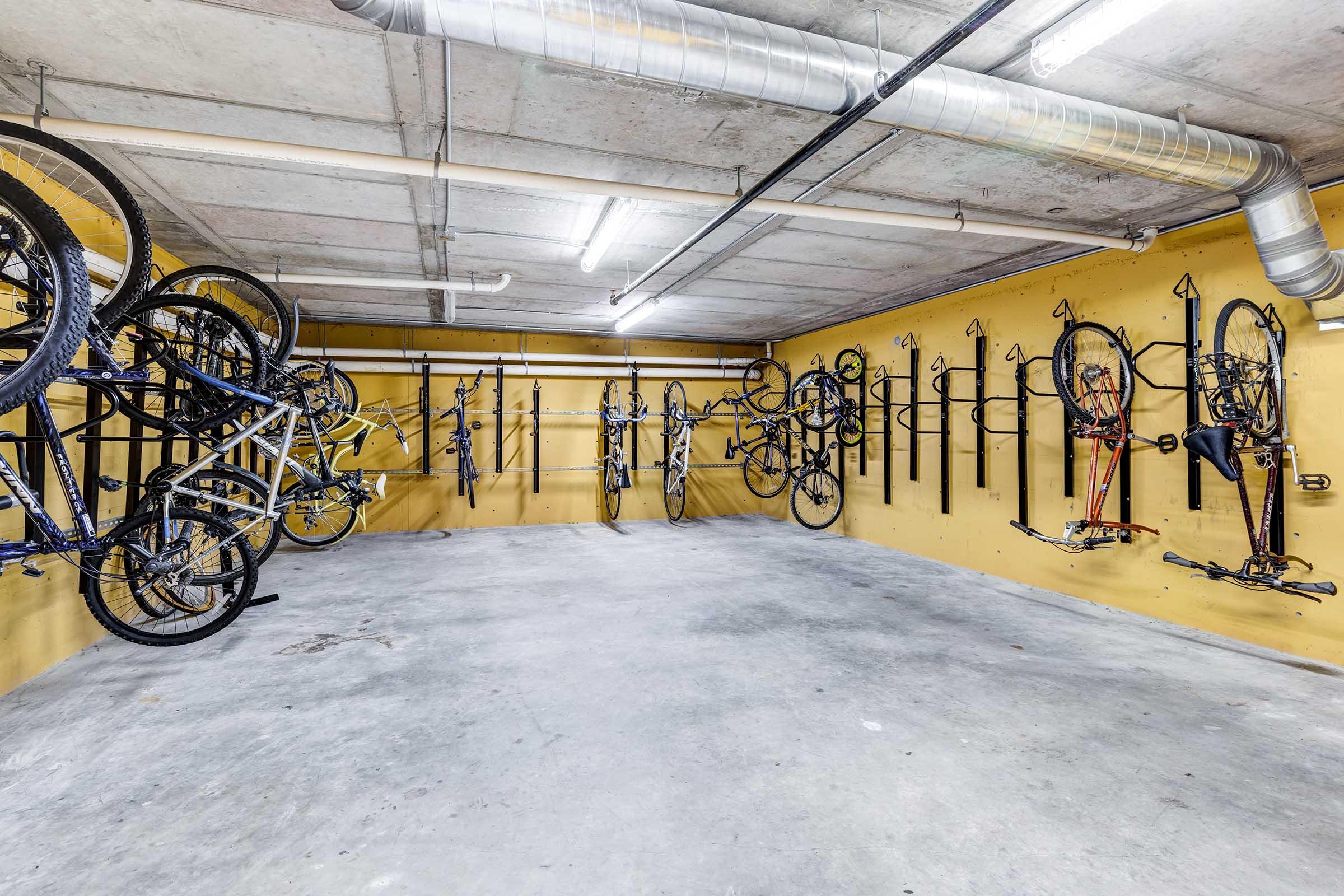 A well-organized indoor bike storage facility with several bicycles mounted on wall racks.