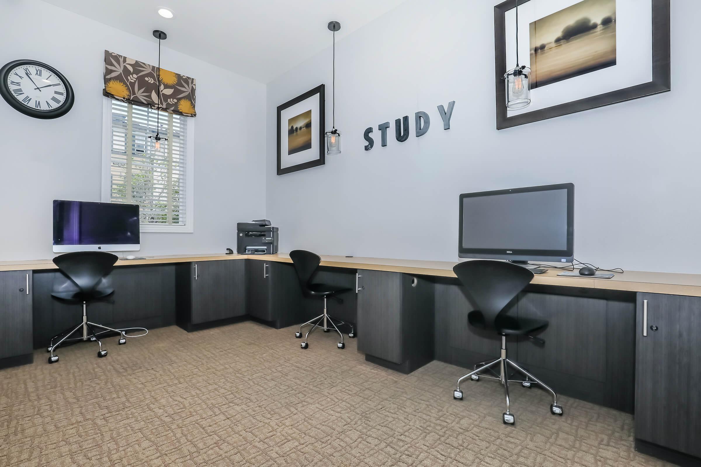 a desk with a computer and a chair in a room