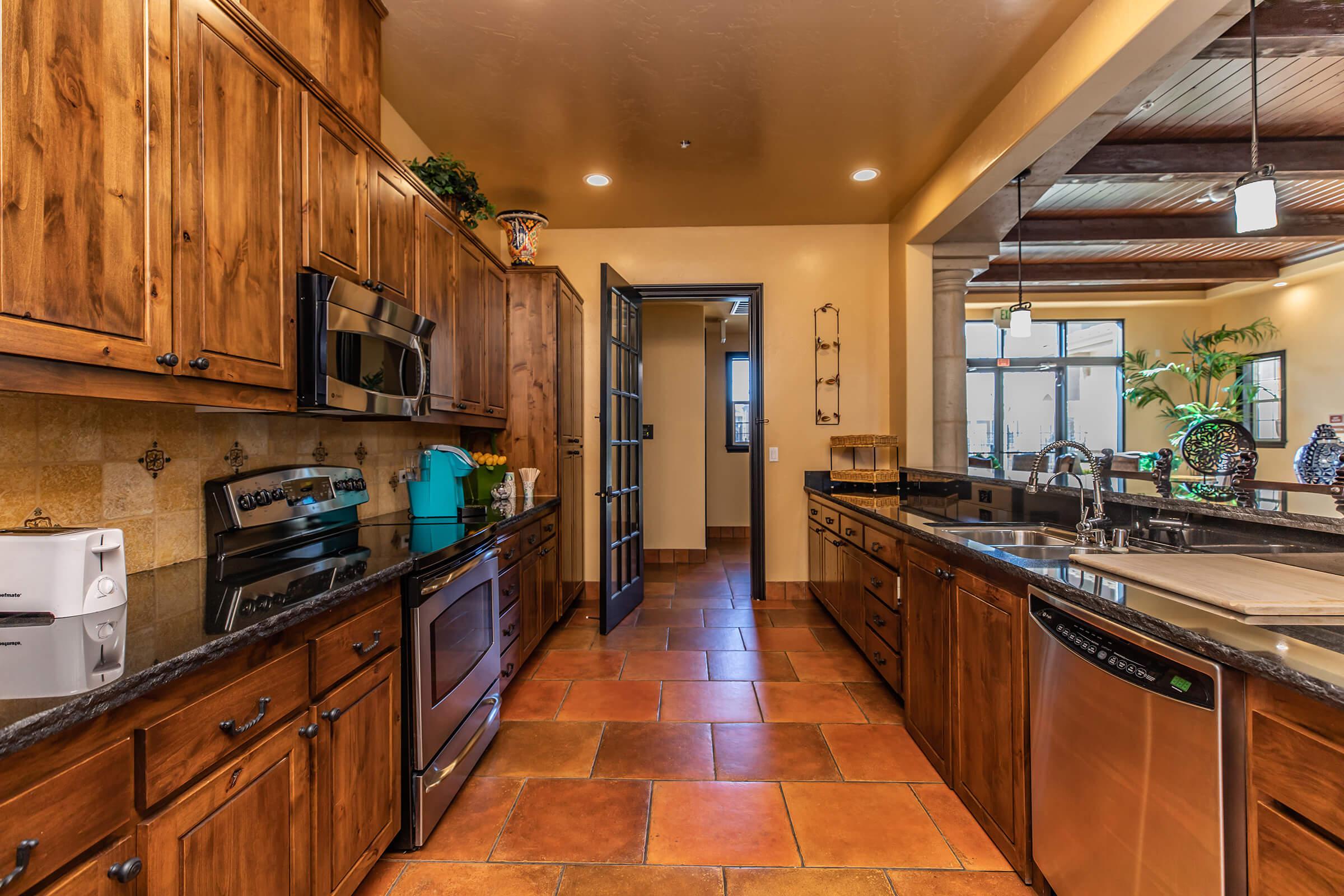 a large kitchen with stainless steel appliances and wooden cabinets