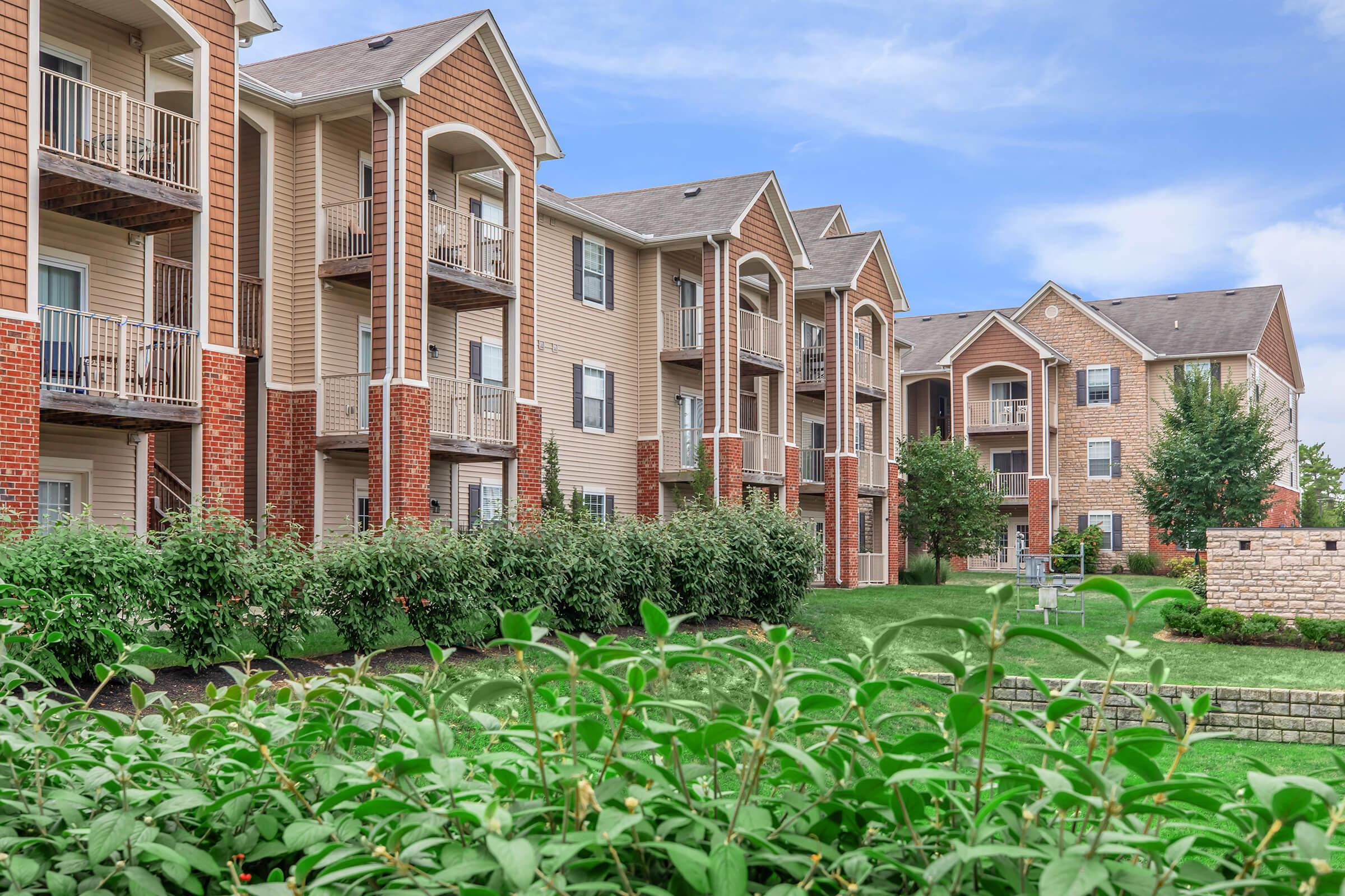 a large brick building with green grass in front of a house