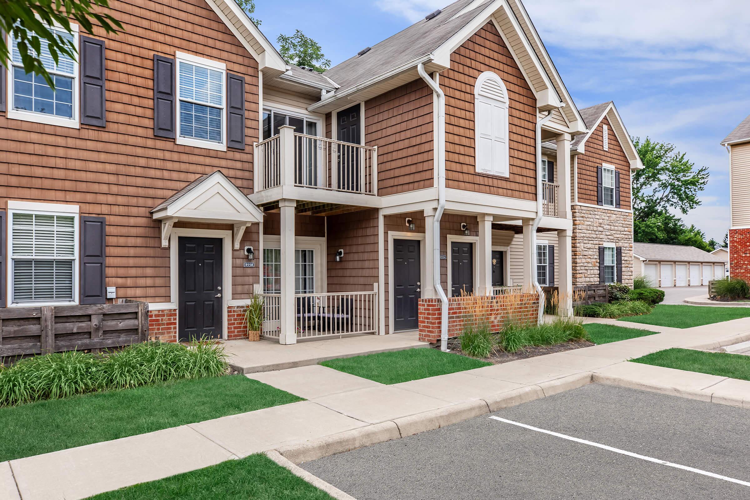 a large brick building with grass in front of a house