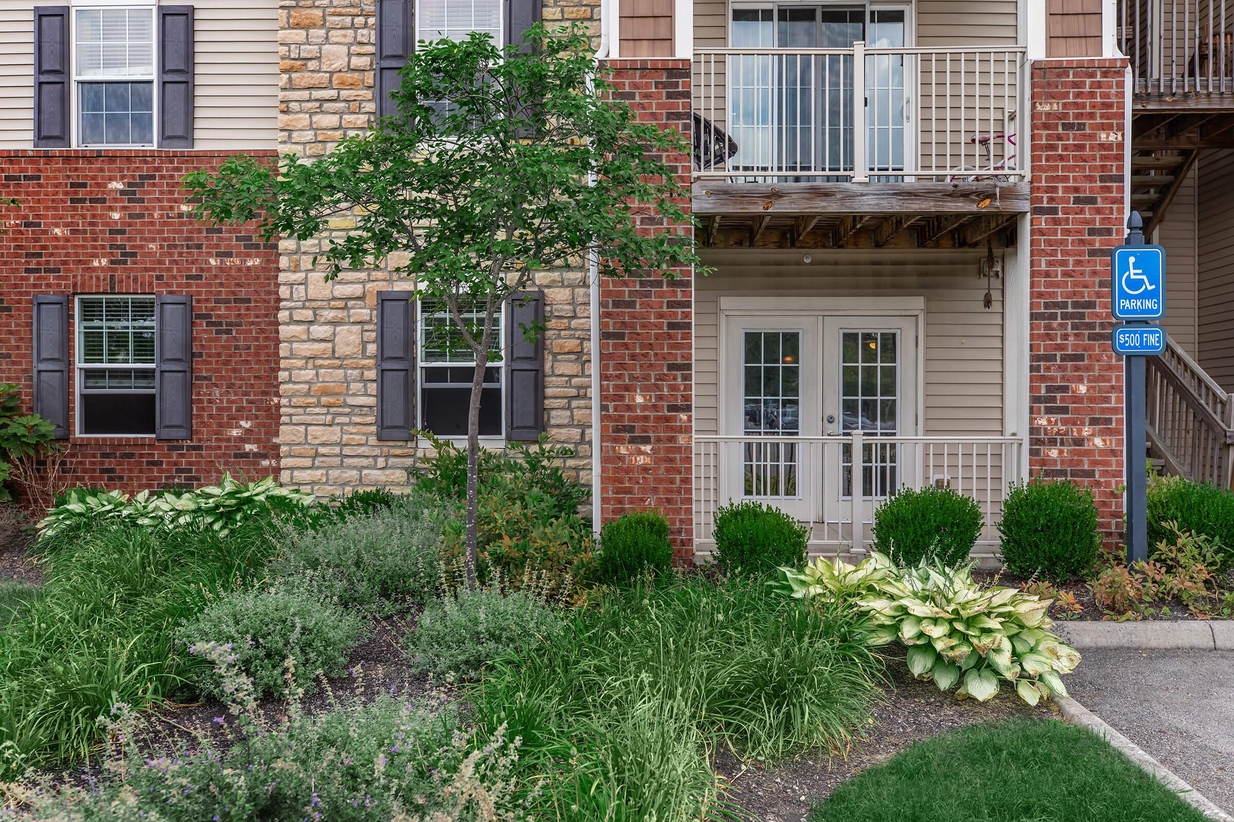 a house with bushes in front of a brick building