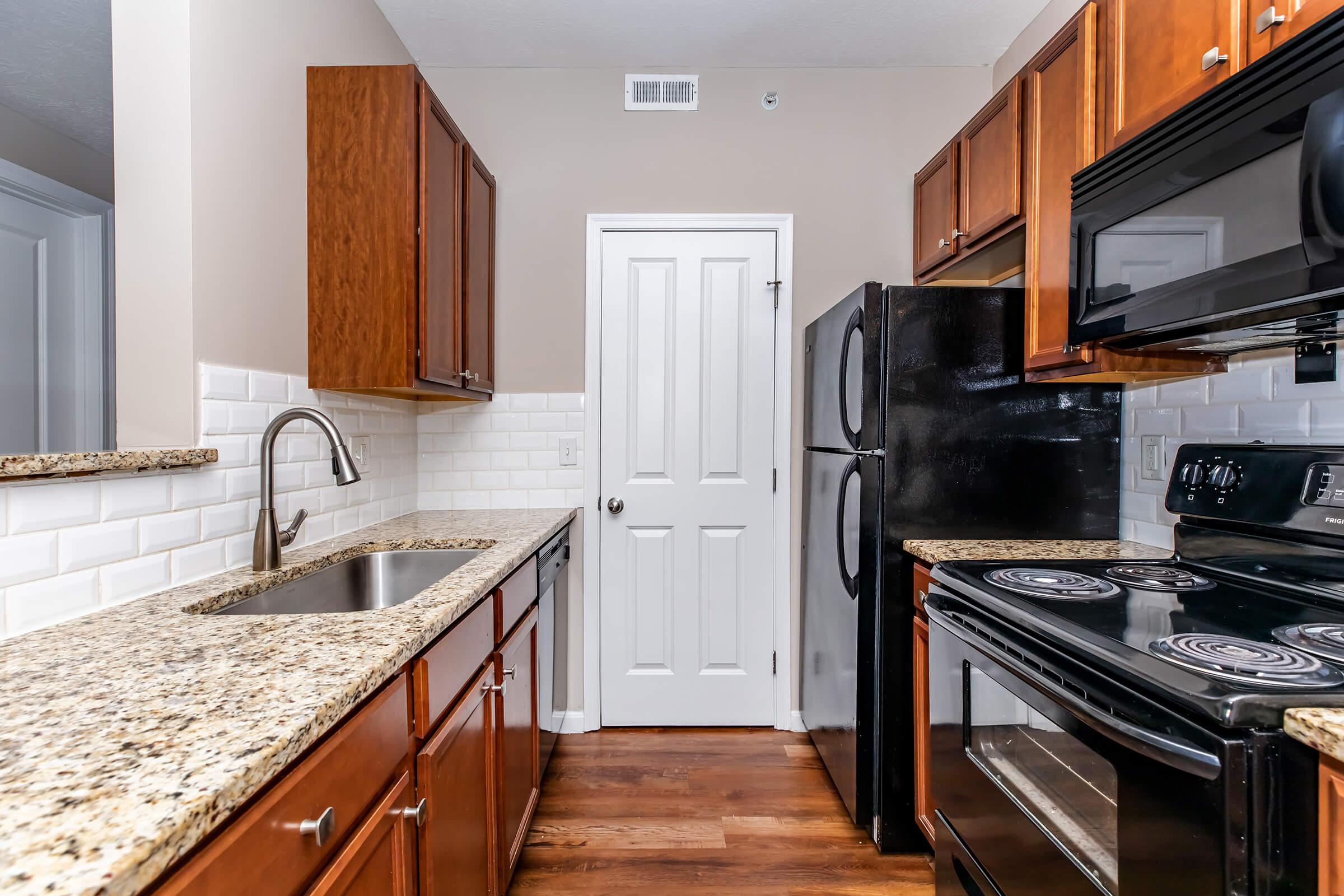 a modern kitchen with stainless steel appliances and wooden cabinets