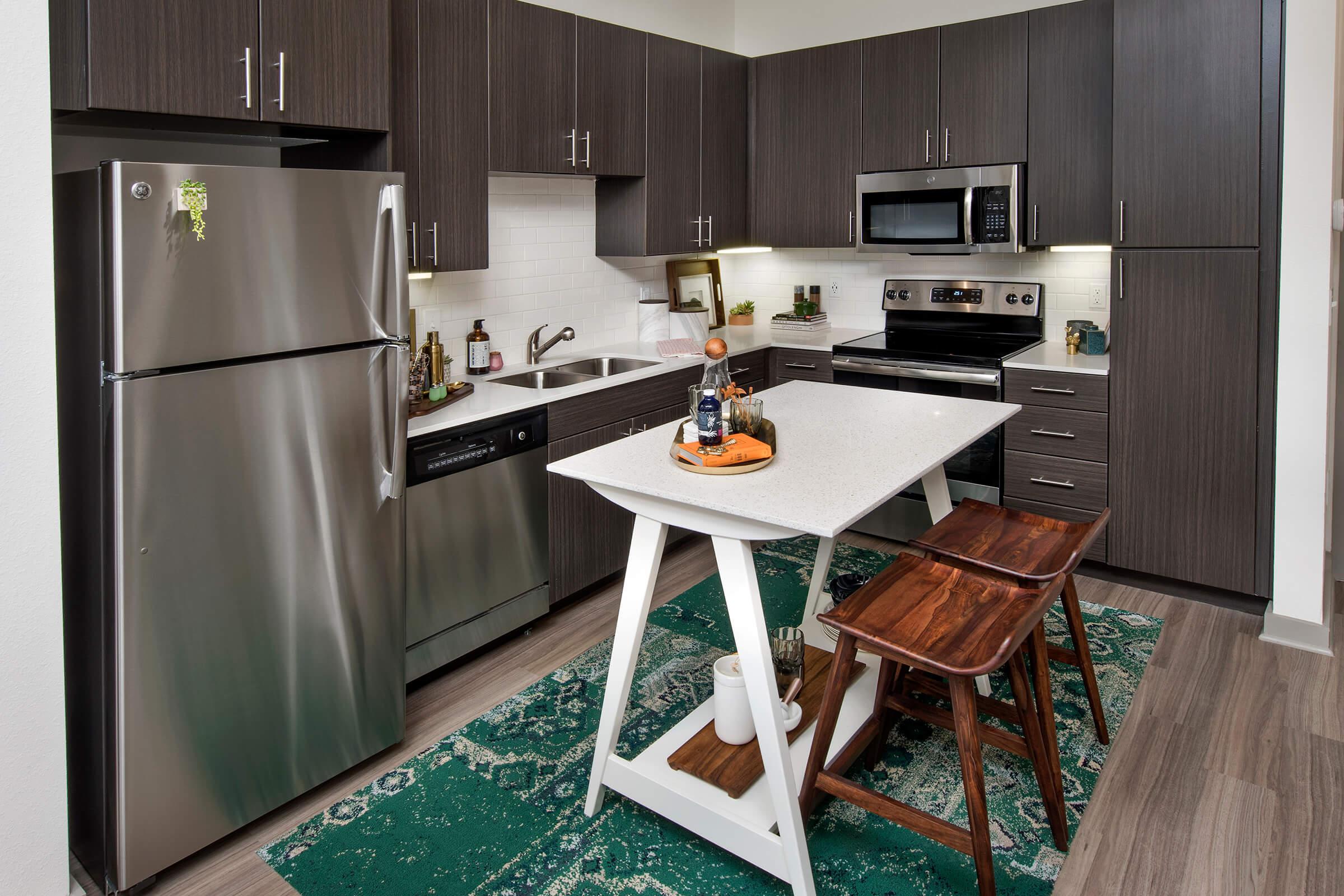 a modern kitchen with stainless steel appliances and wooden cabinets