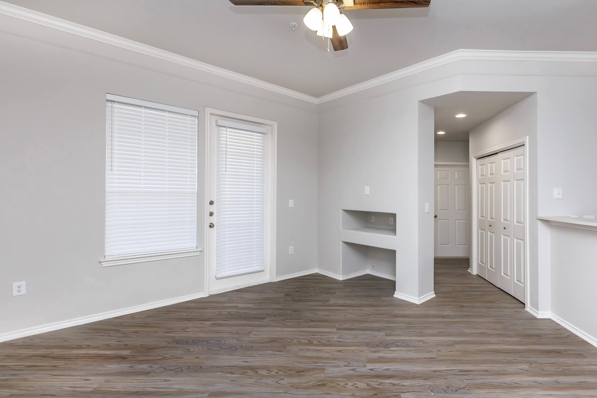 a room with white walls and a large window