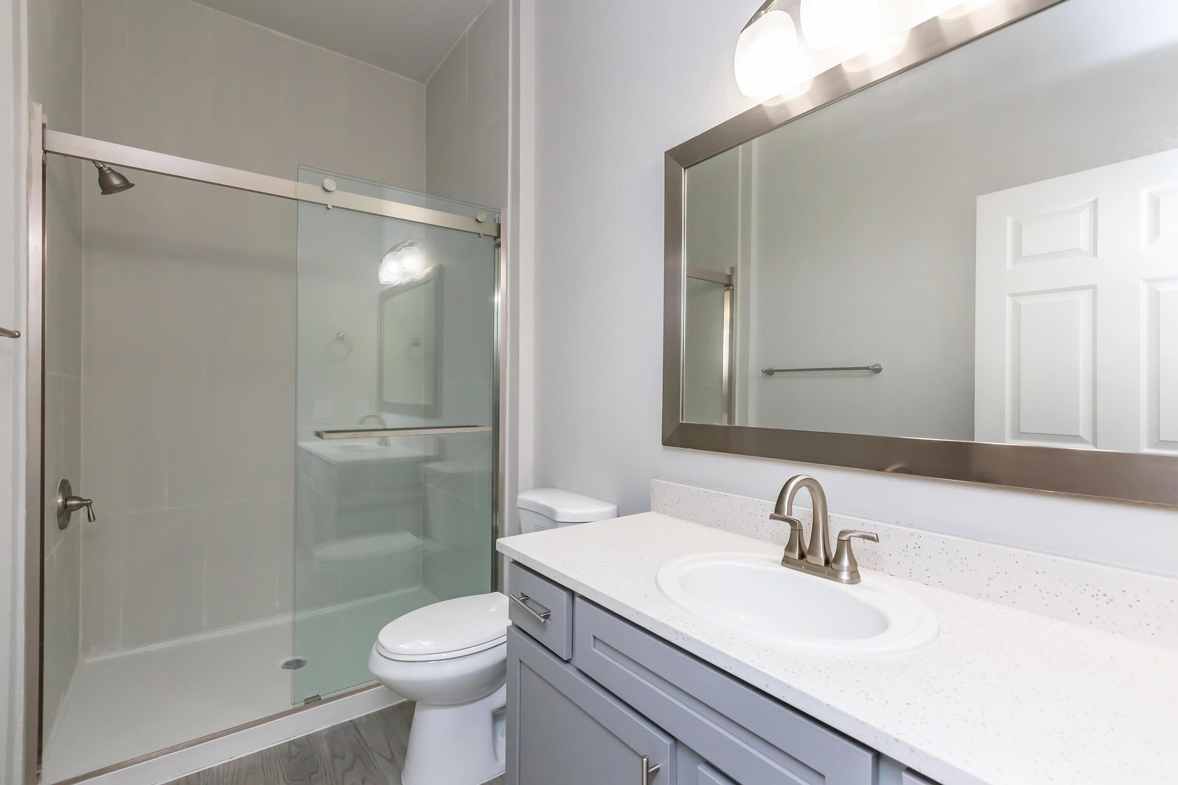 a white sink sitting next to a glass shower door
