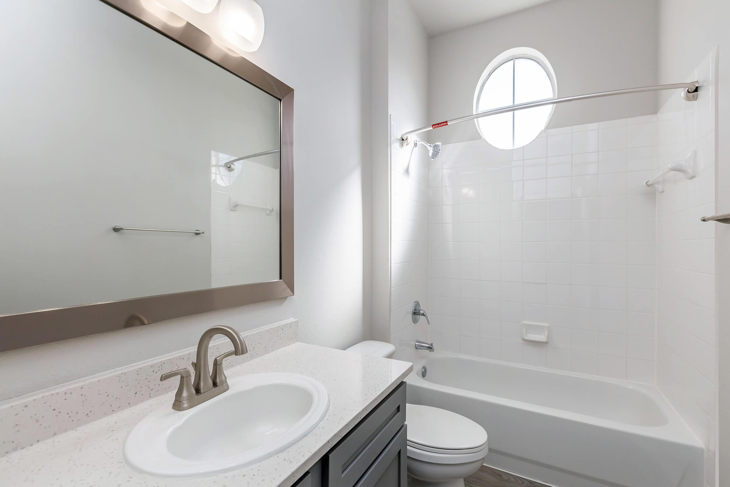 a white sink sitting under a mirror