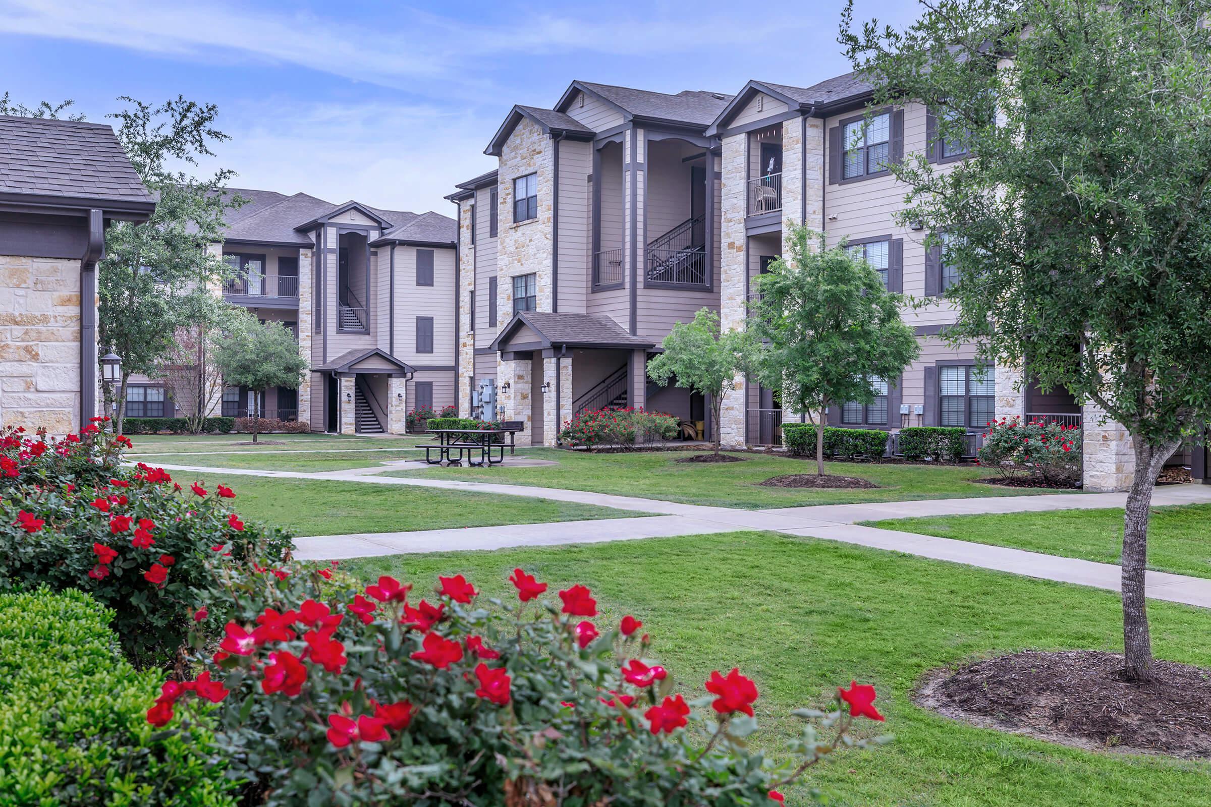 a close up of a flower garden in front of a house