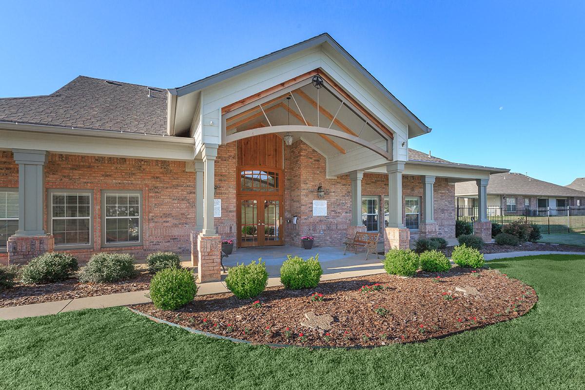 a large brick building with grass in front of a house