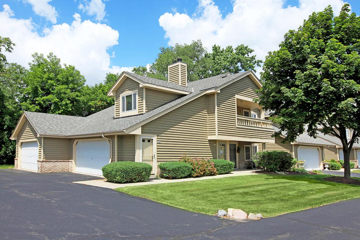 a large brick building with grass in front of a house