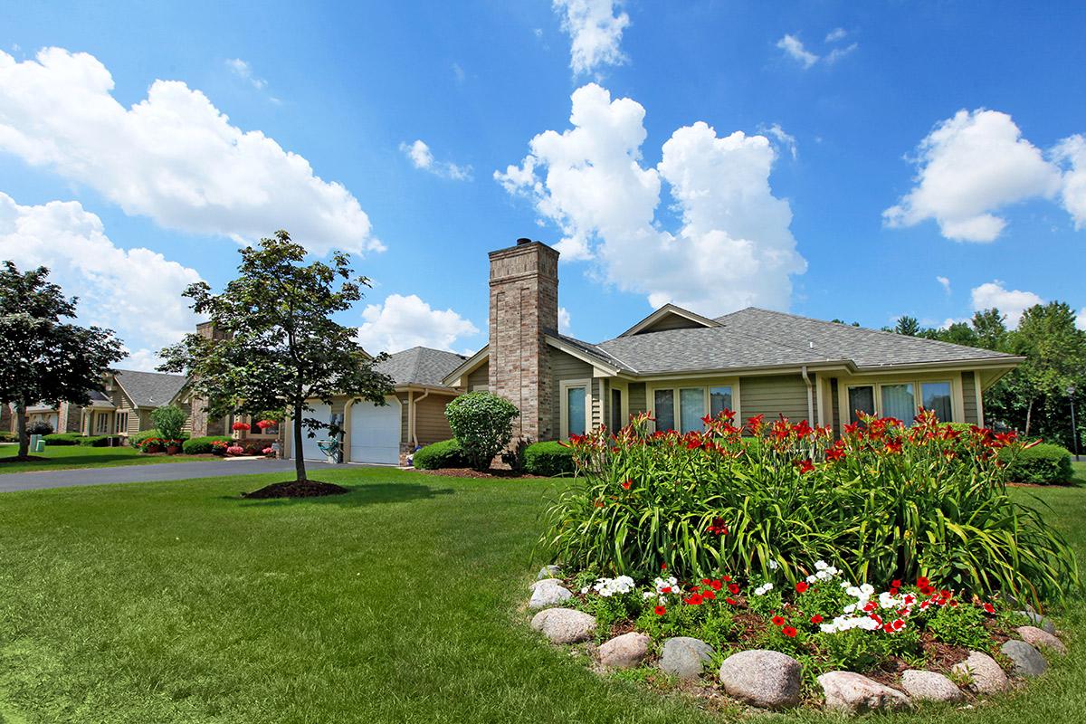 a close up of a flower garden in front of a house