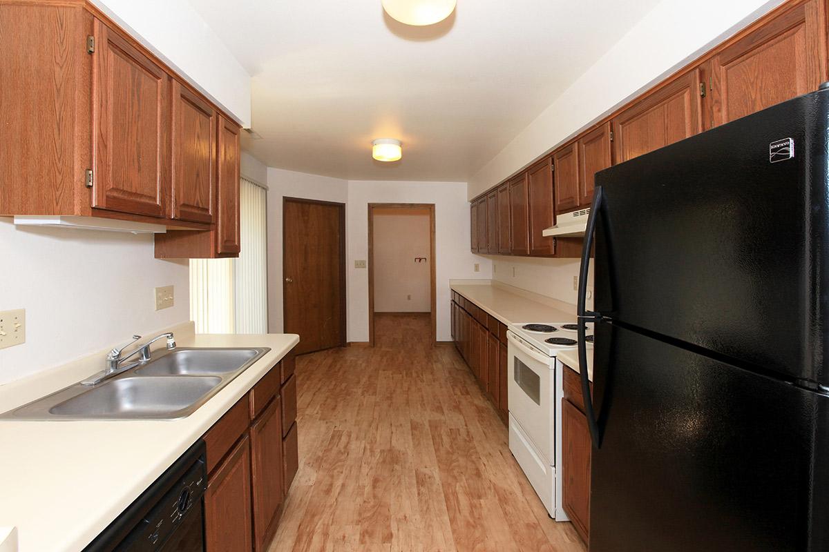 a large kitchen with stainless steel appliances and wooden cabinets