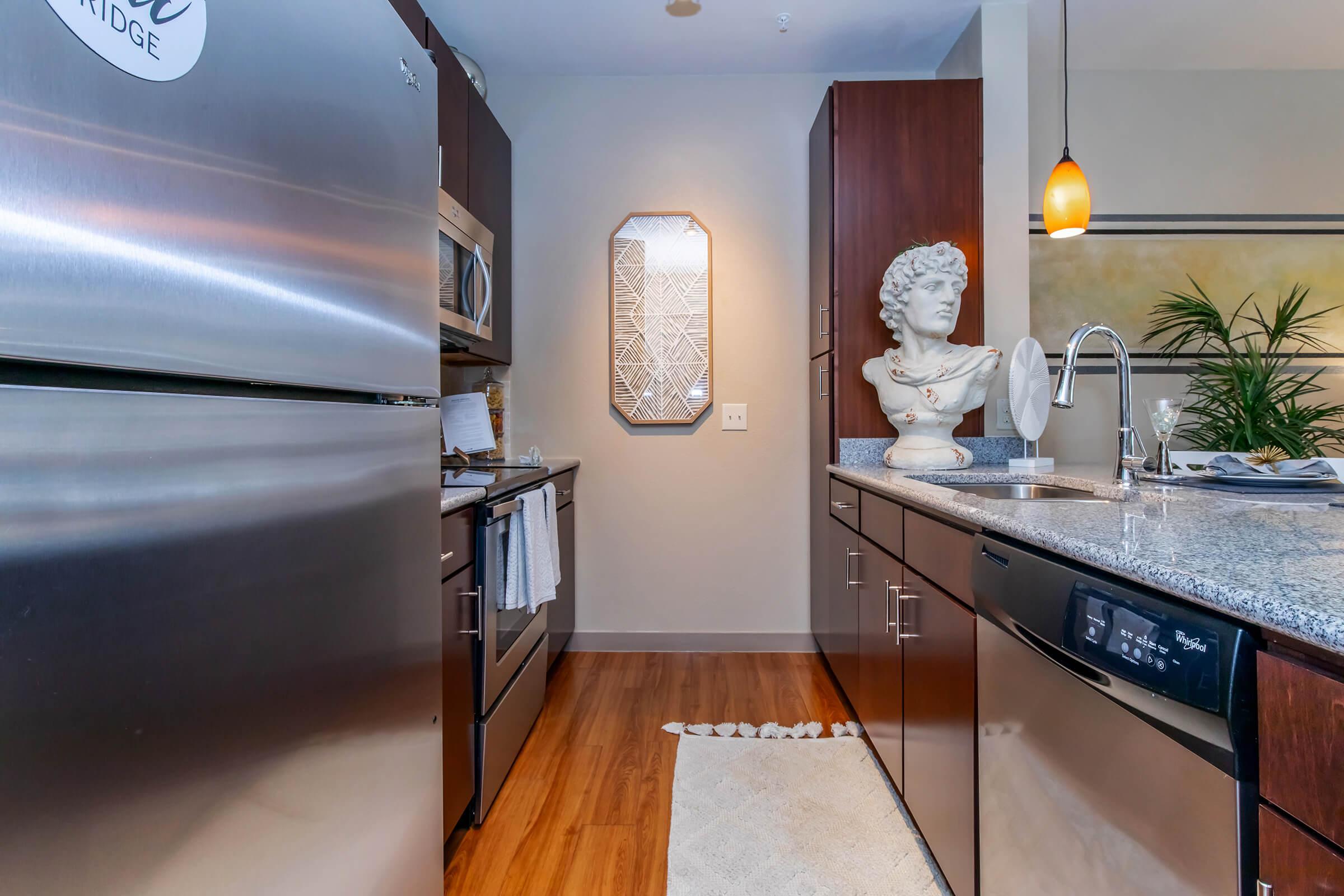 a modern kitchen with stainless steel appliances and wooden cabinets