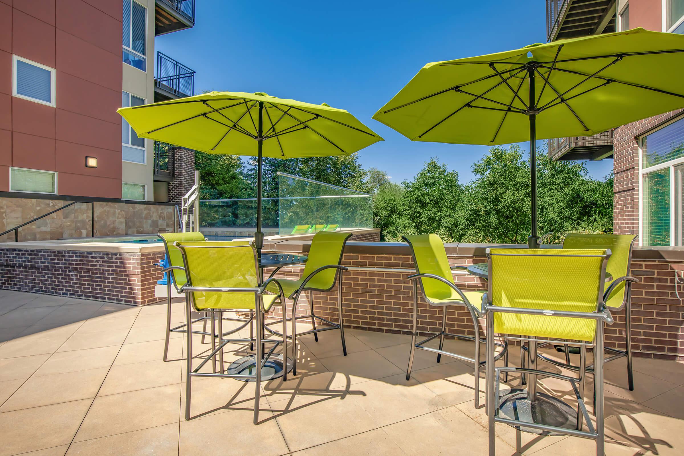 a group of lawn chairs sitting on top of a yellow umbrella