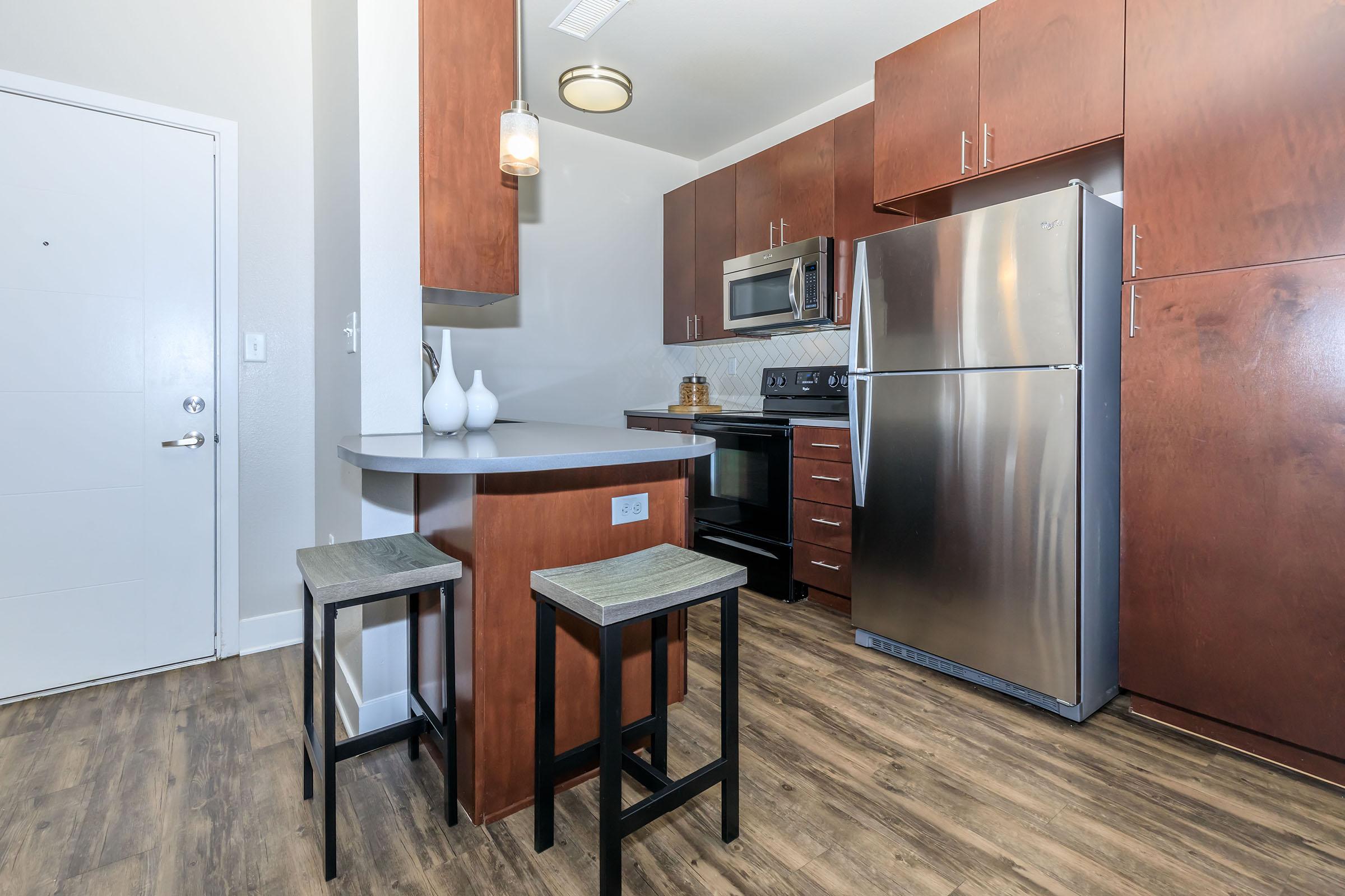 a modern kitchen with stainless steel appliances and wooden cabinets