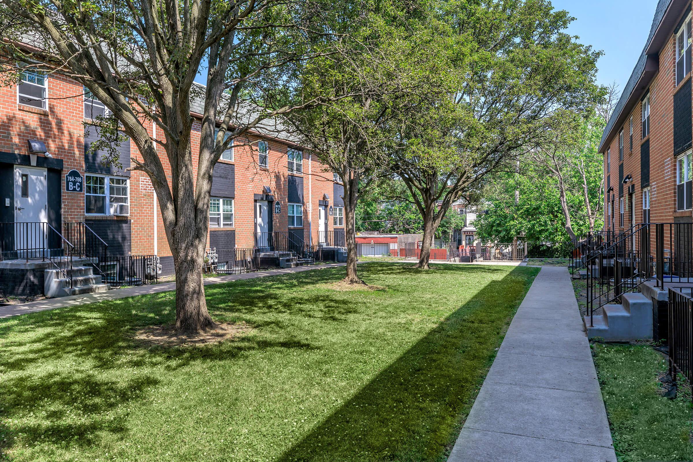 a large brick building with grass in front of a house