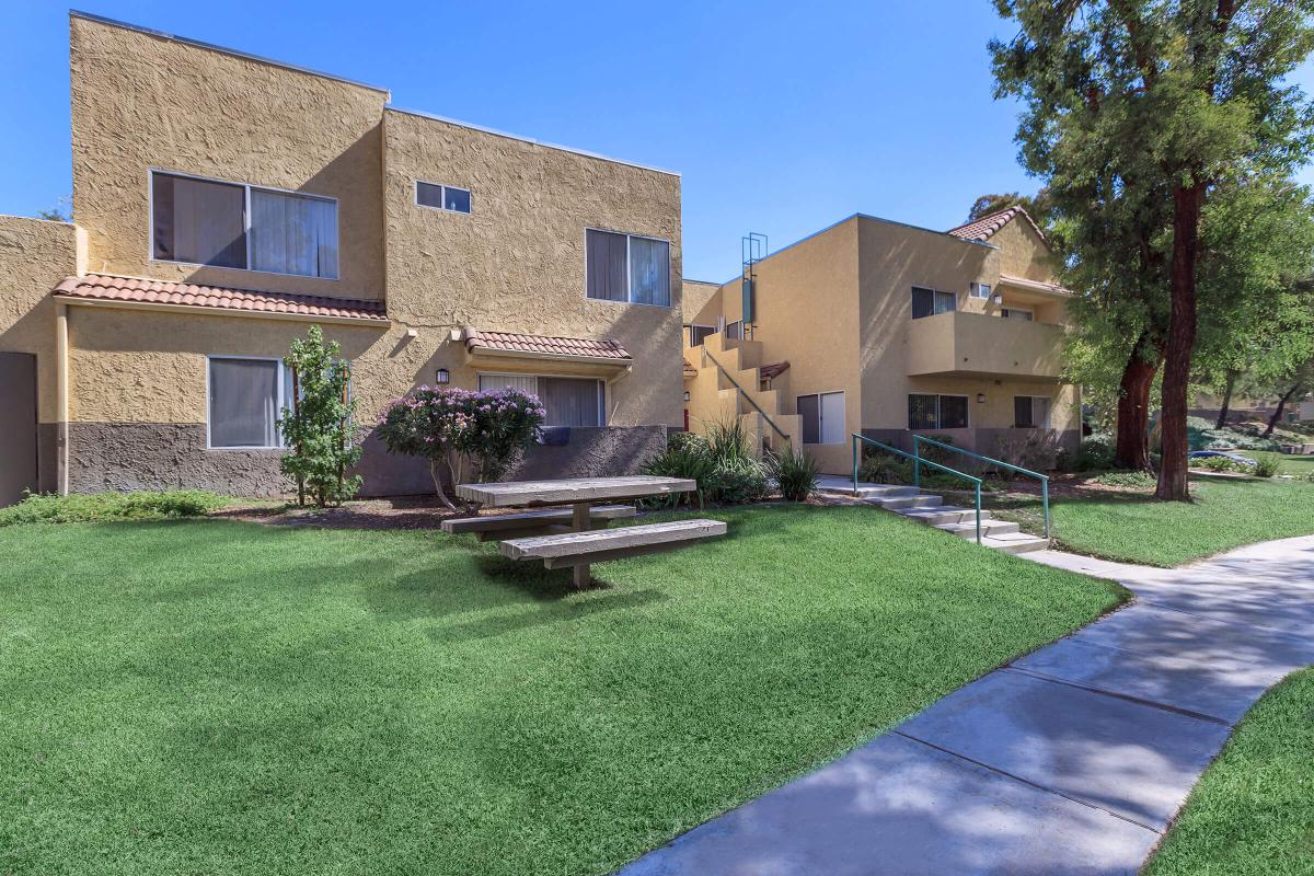 a house with a lawn in front of a brick building