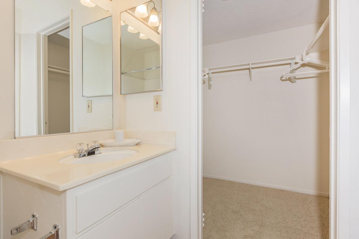 a white sink sitting under a mirror