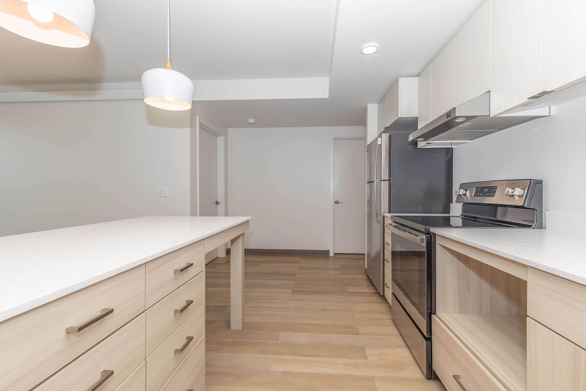 a kitchen with wooden cabinets and a bed