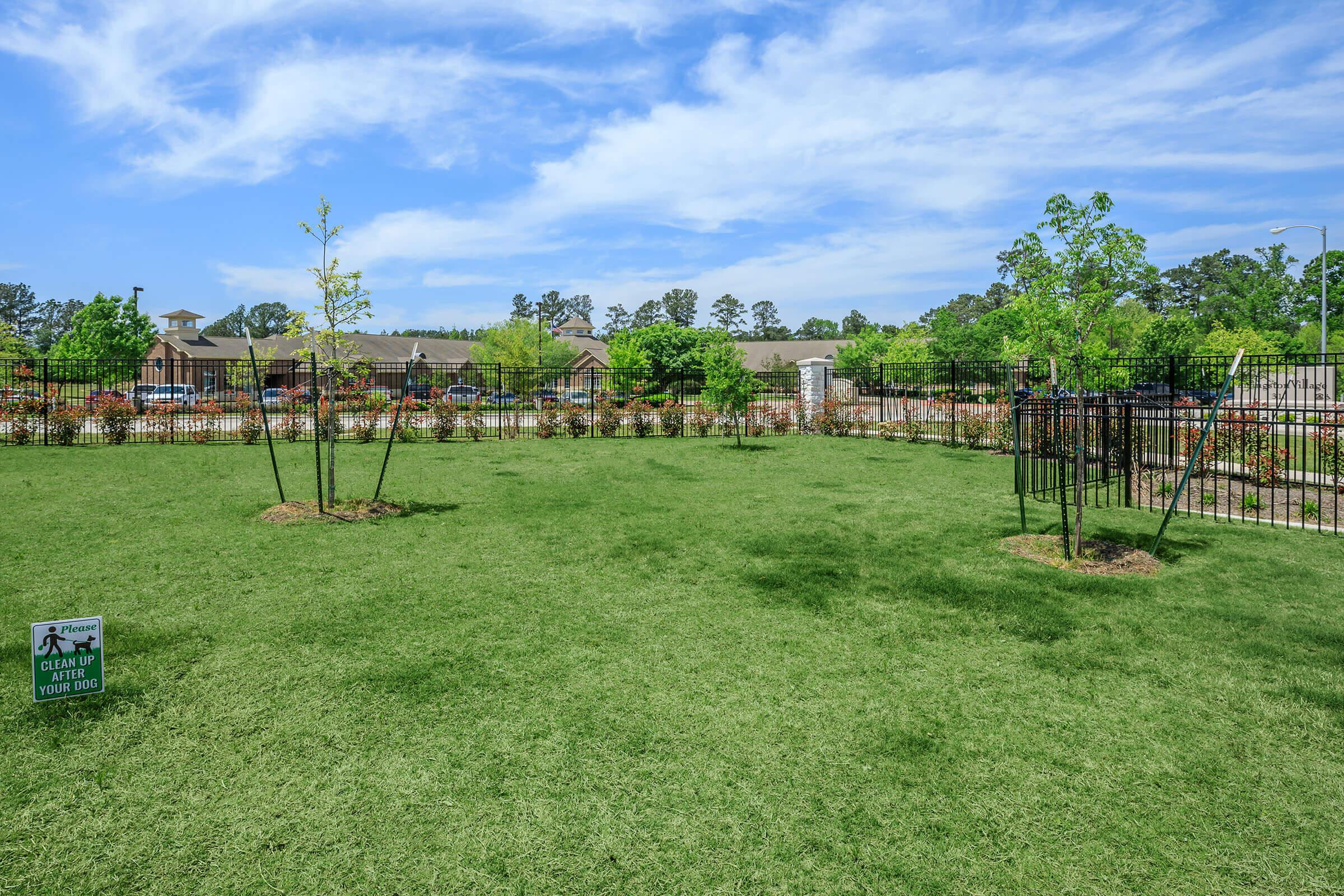 a large green field with trees in the background