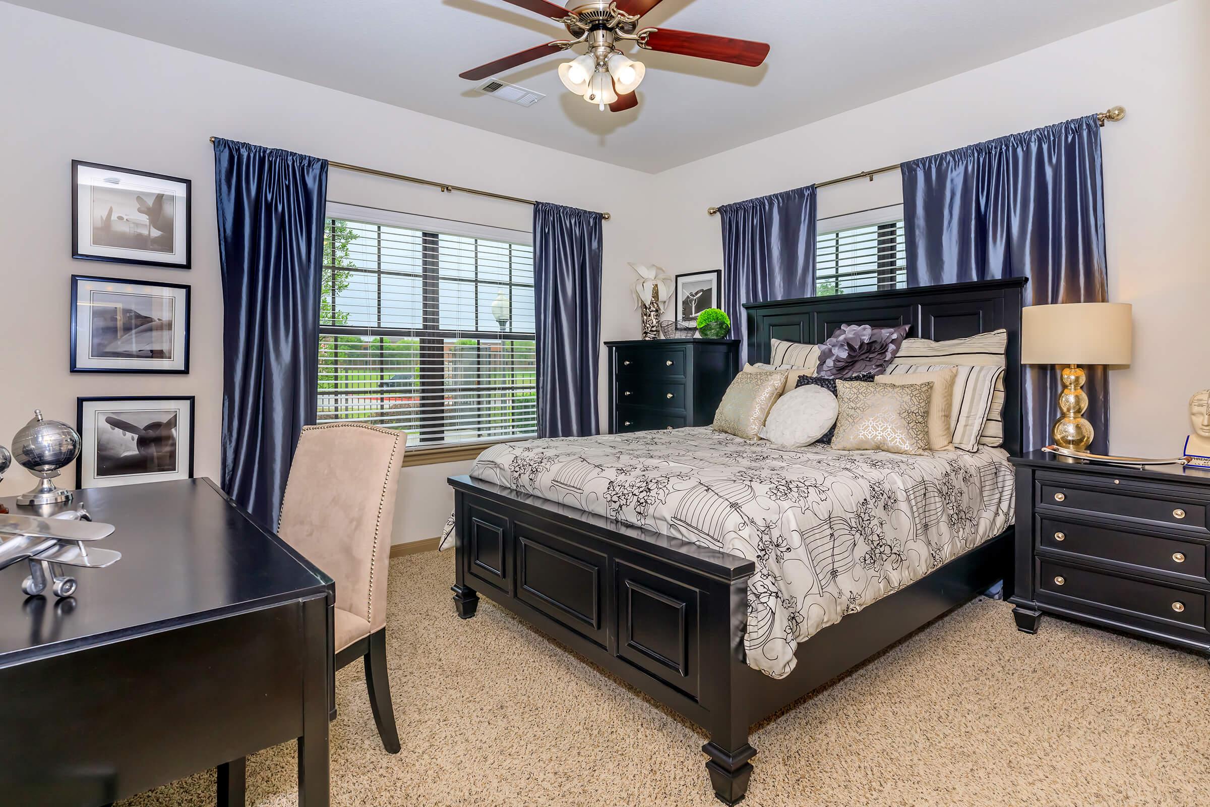 a bedroom with a bed and desk in a room