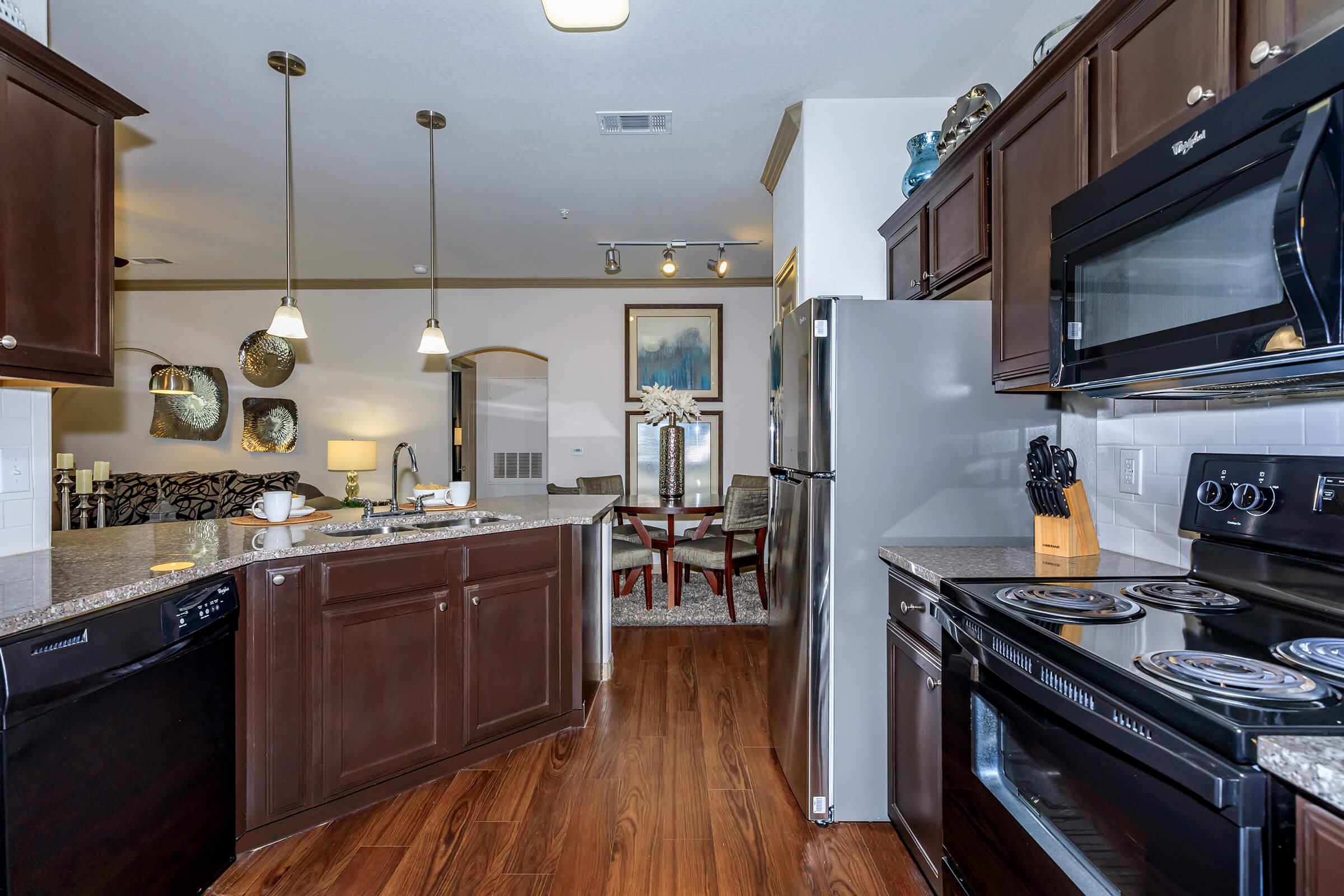 a large kitchen with stainless steel appliances and wooden cabinets