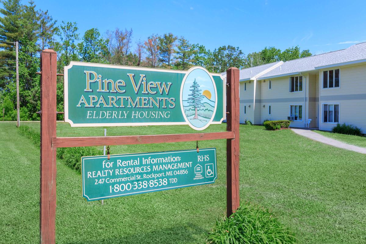 a sign in front of a green field