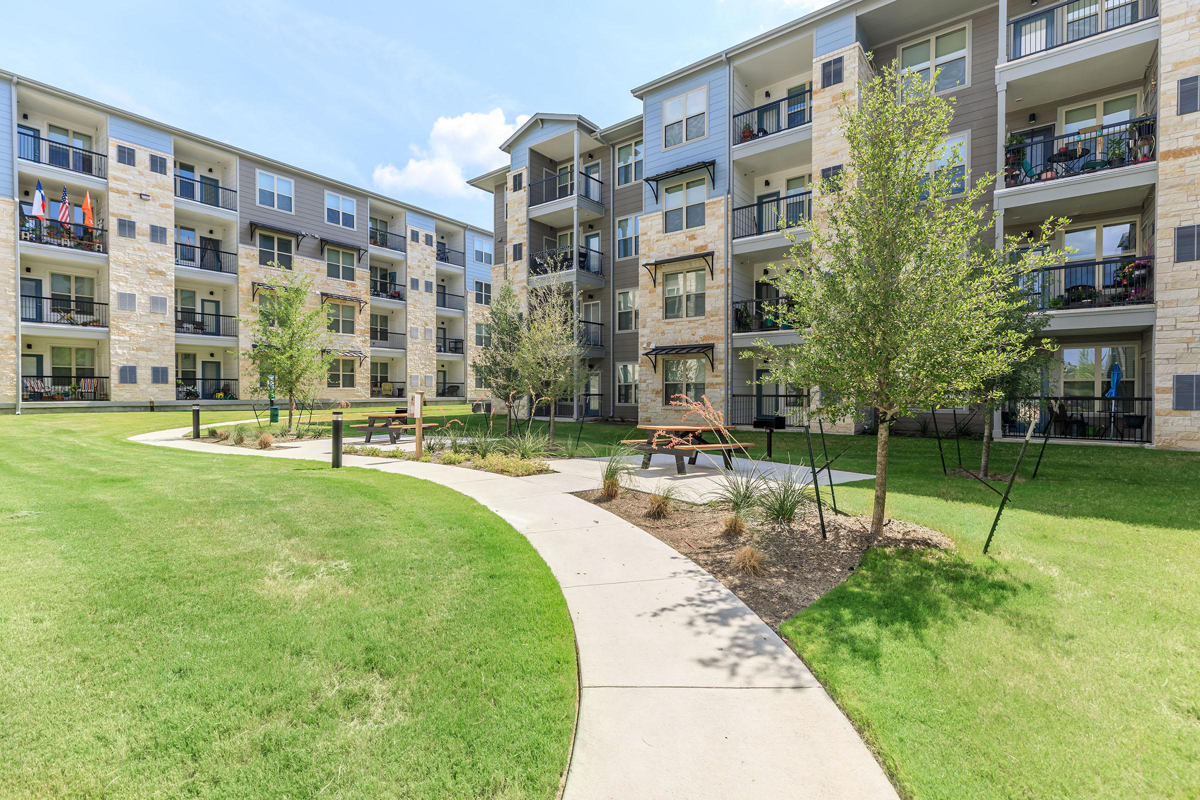 Senior Apartments in Pflugerville - Legacy Ranch at Dessau East - Grassy Lawn and Building Exterior