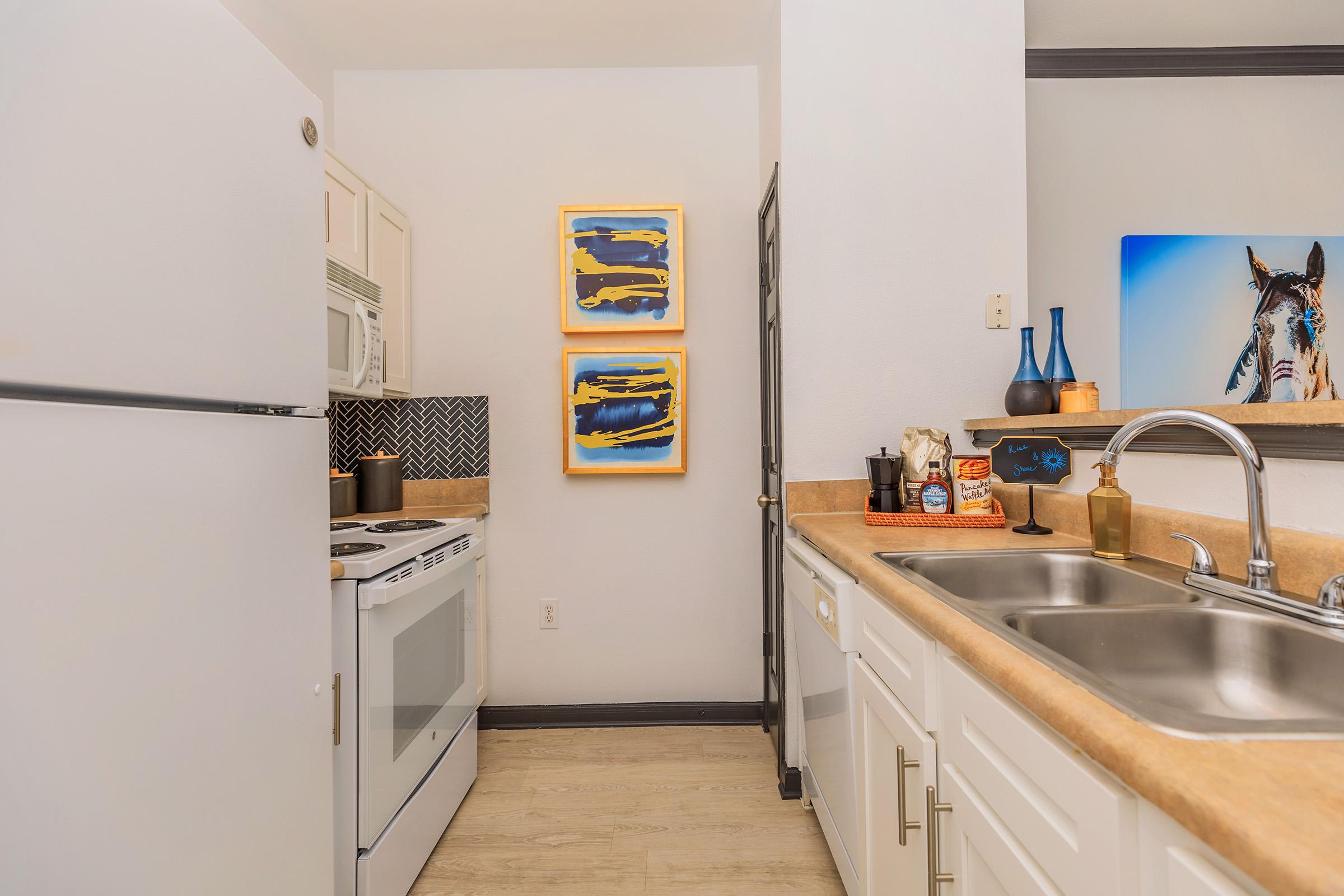 a kitchen with a stove sink and refrigerator