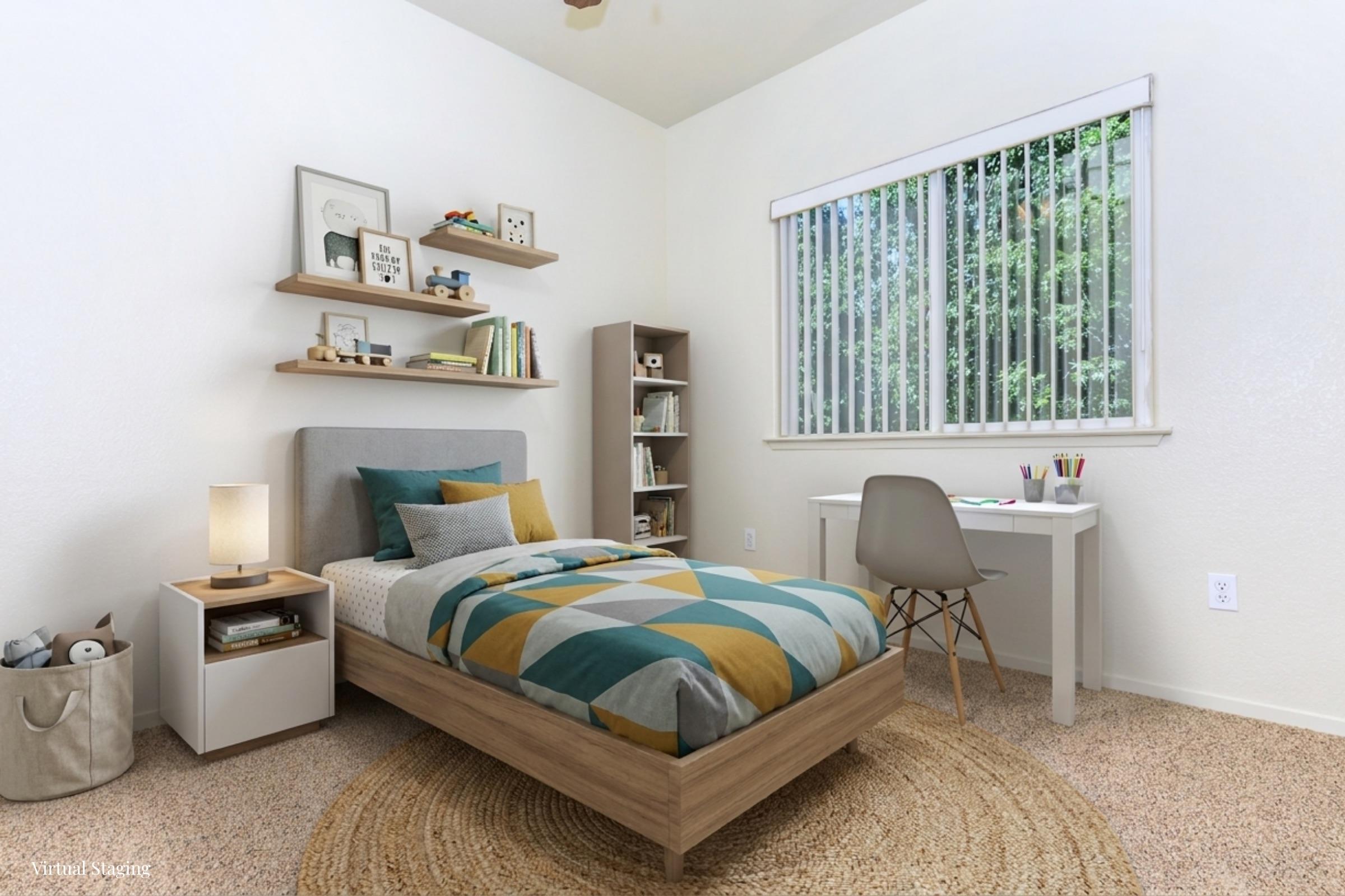 A cozy bedroom featuring a bed with a geometric patterned bedspread, a light wooden bed frame, and a bedside lamp. A small bookshelf with books and decorative items is visible, along with a desk and chair near a window with greenery outside. The floor is covered with a soft, round rug.