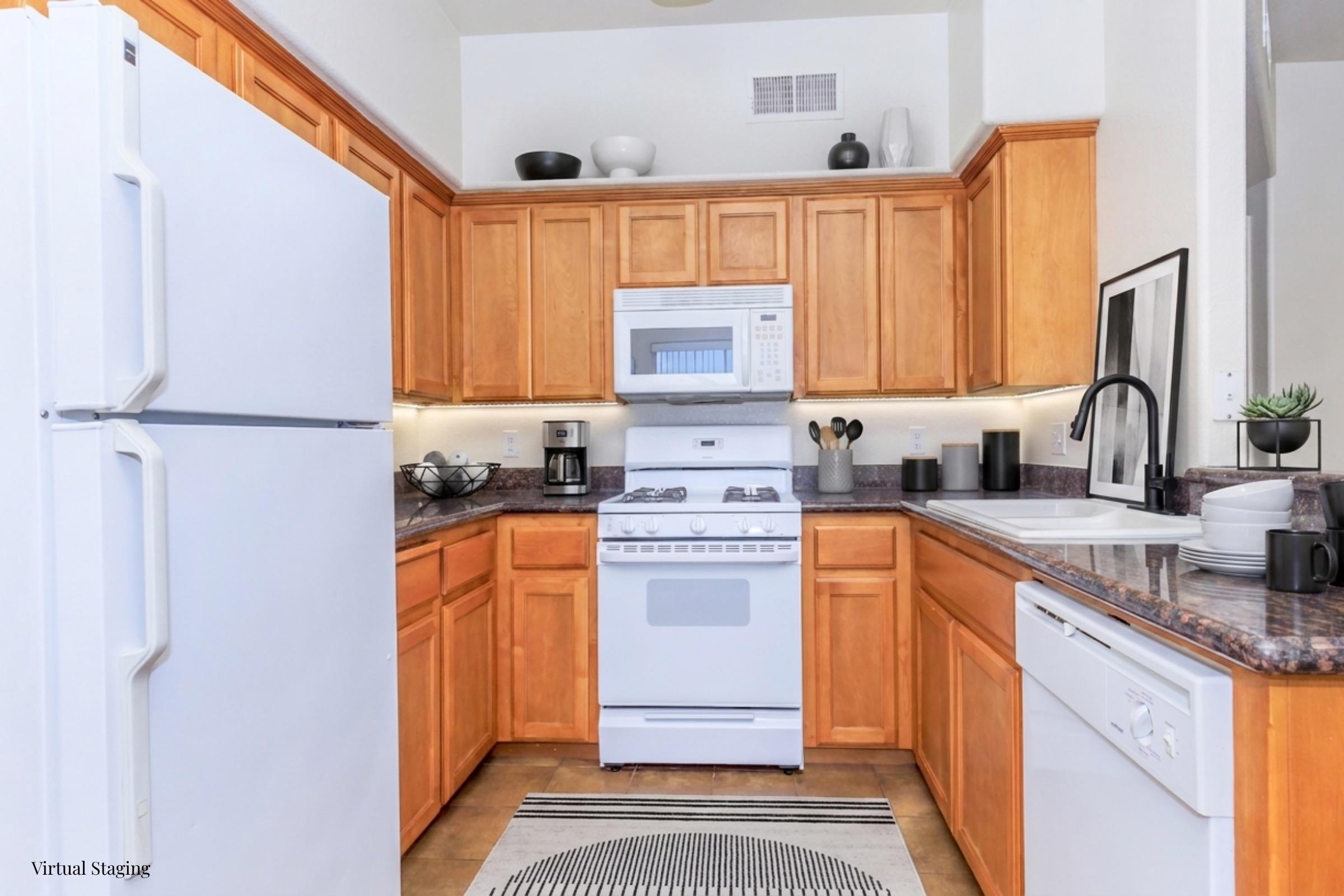 A modern kitchen featuring wooden cabinetry and granite countertops. It includes a white refrigerator, a gas stove, a microwave, and a dishwasher. The space is organized with kitchen utensils and small decor items, along with a decorative rug on the floor. Bright lighting enhances the inviting atmosphere.