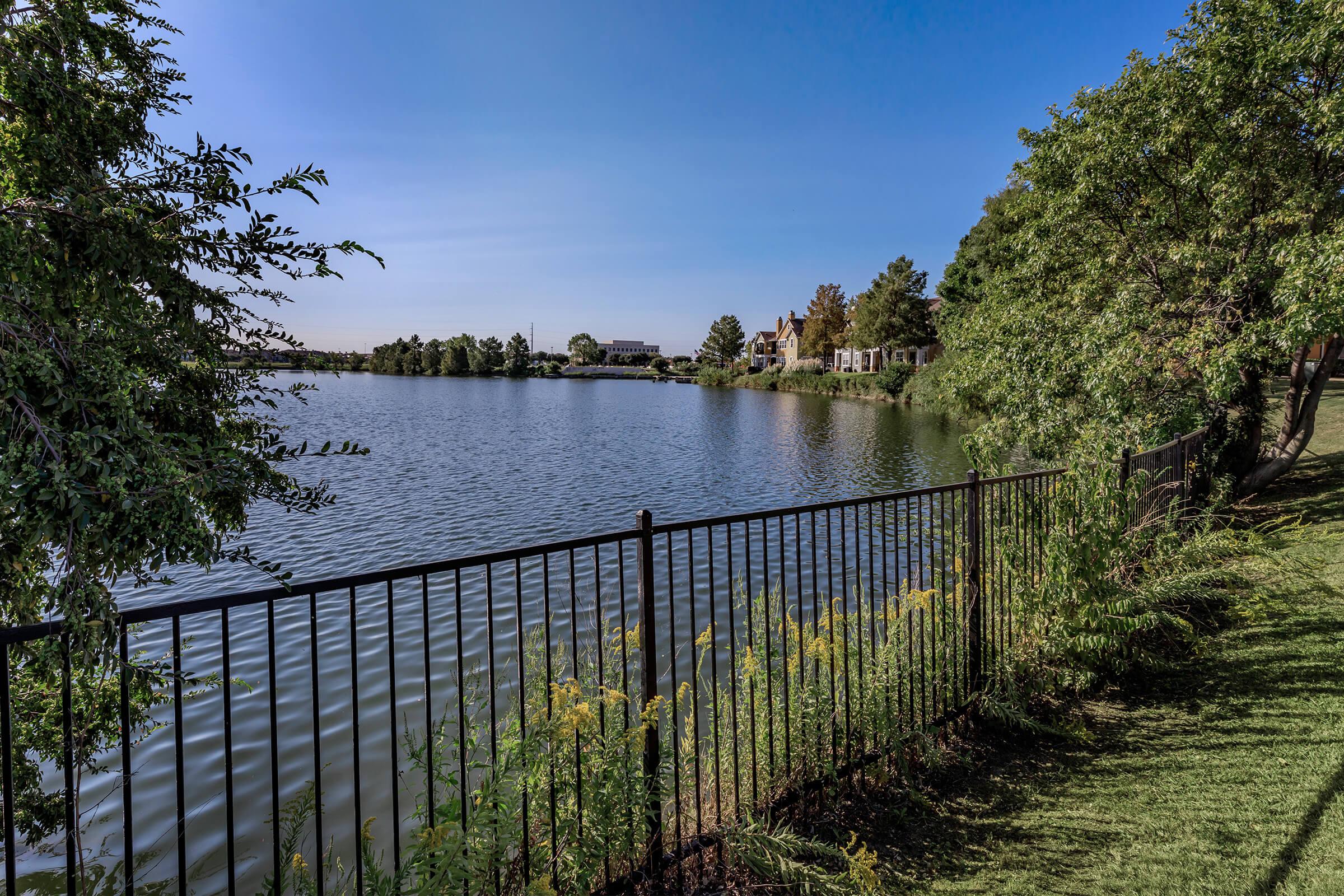 a fence in front of a large body of water