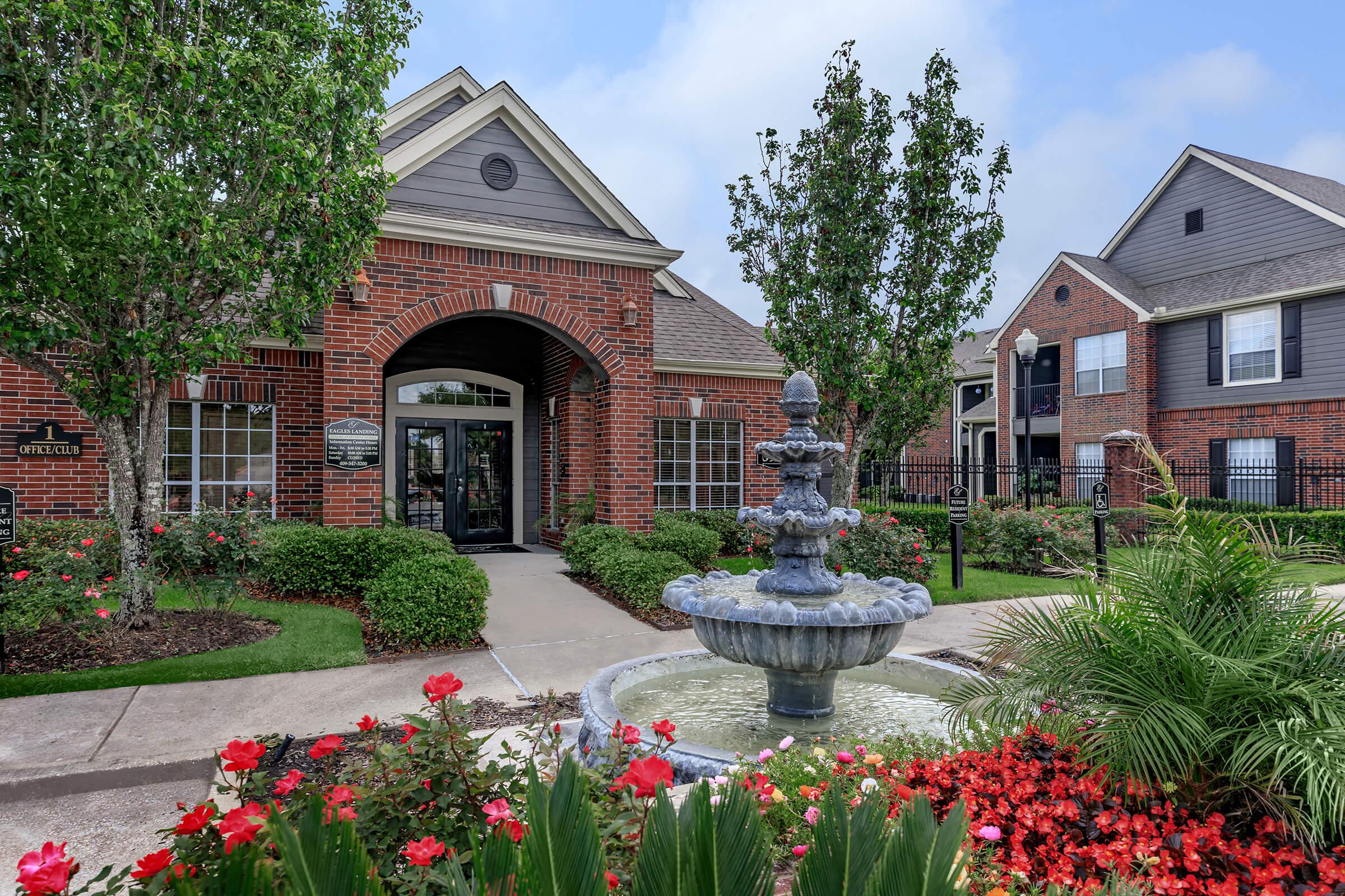 a close up of a flower garden in front of a house