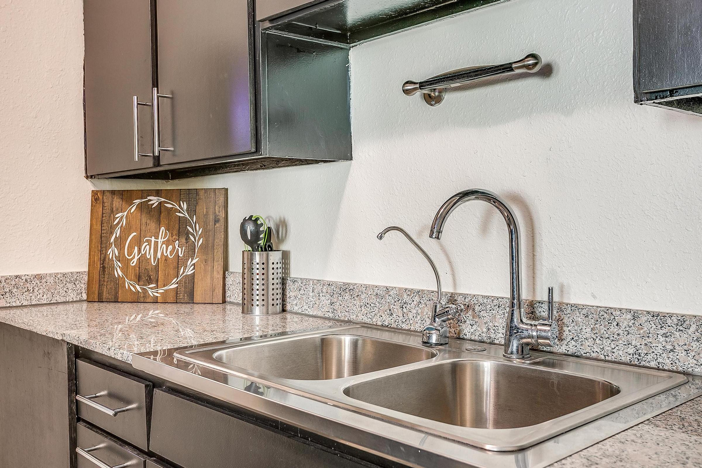 a kitchen with a sink and a mirror