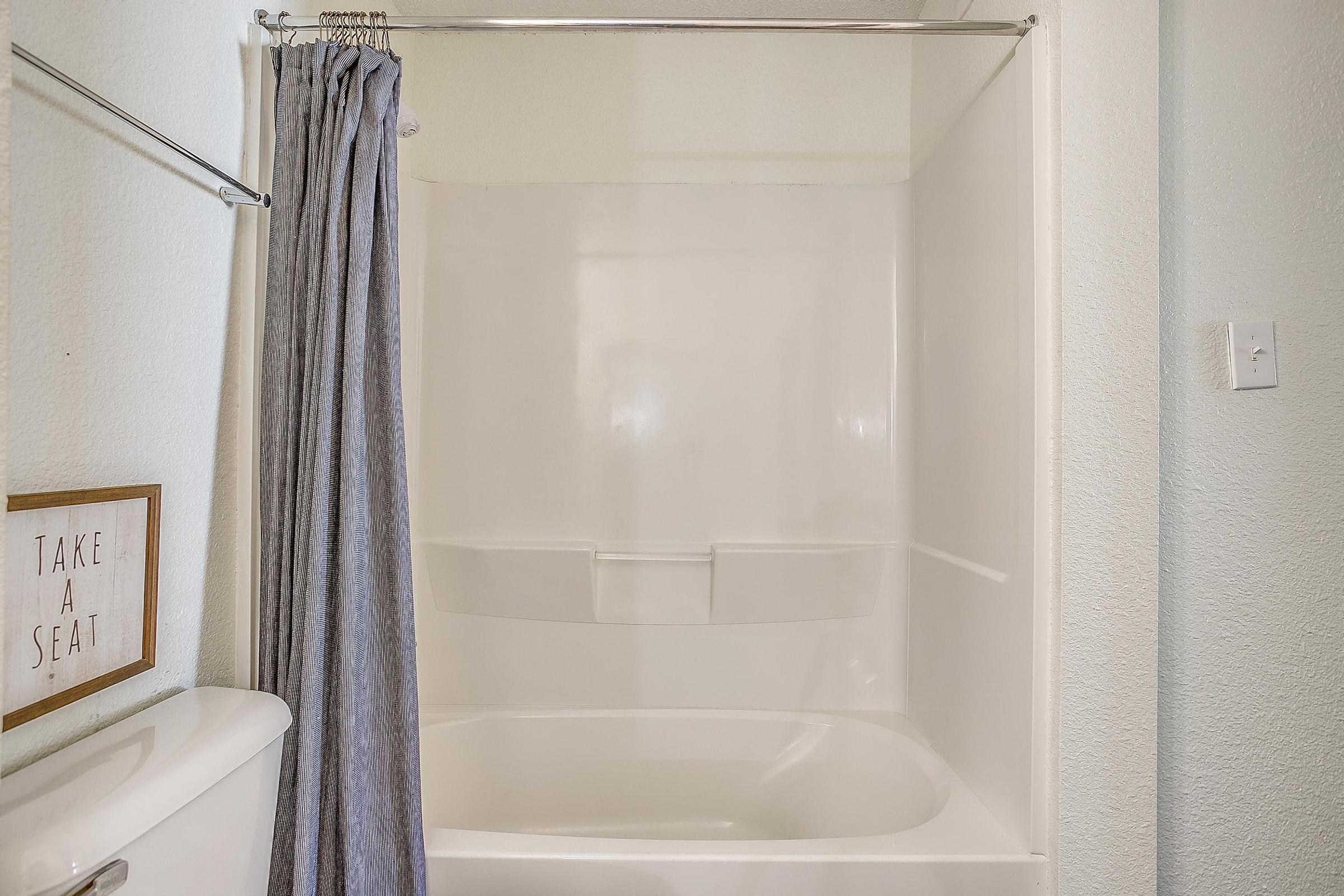 a room with a tub and shower curtain