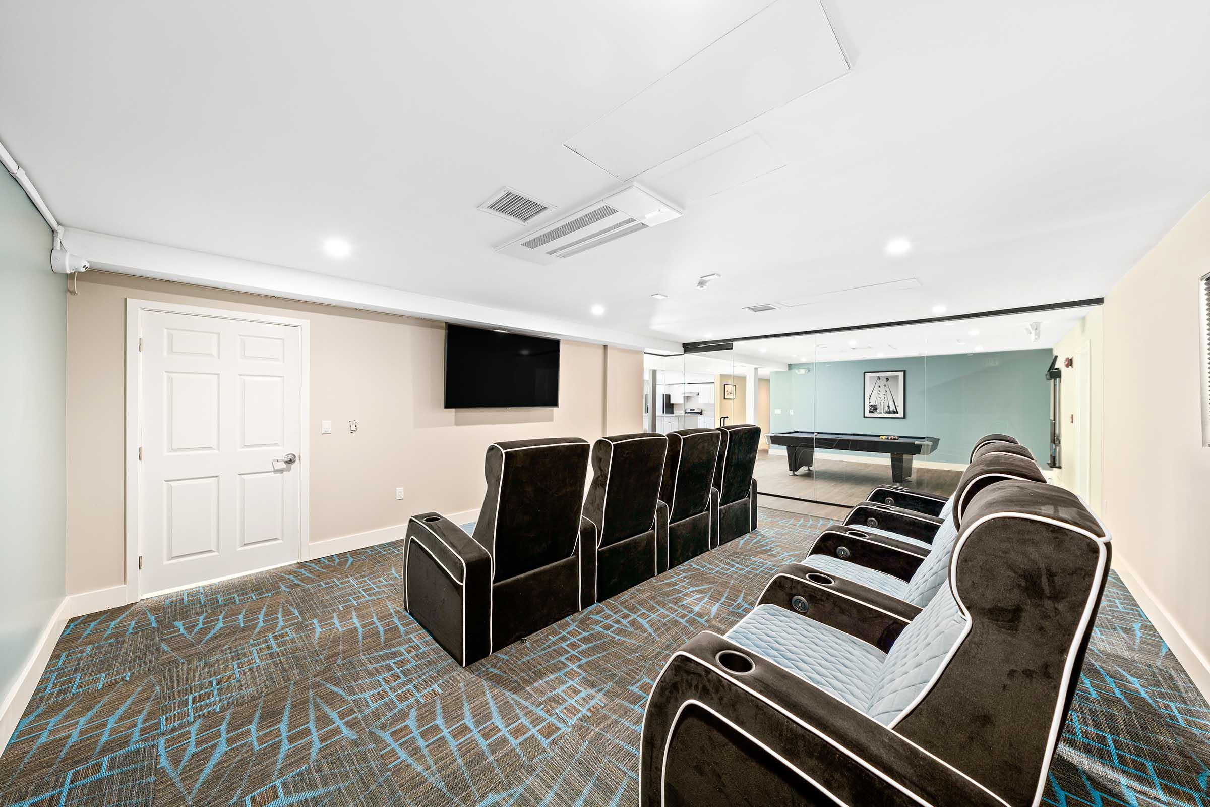 a theater room with a tv and seating