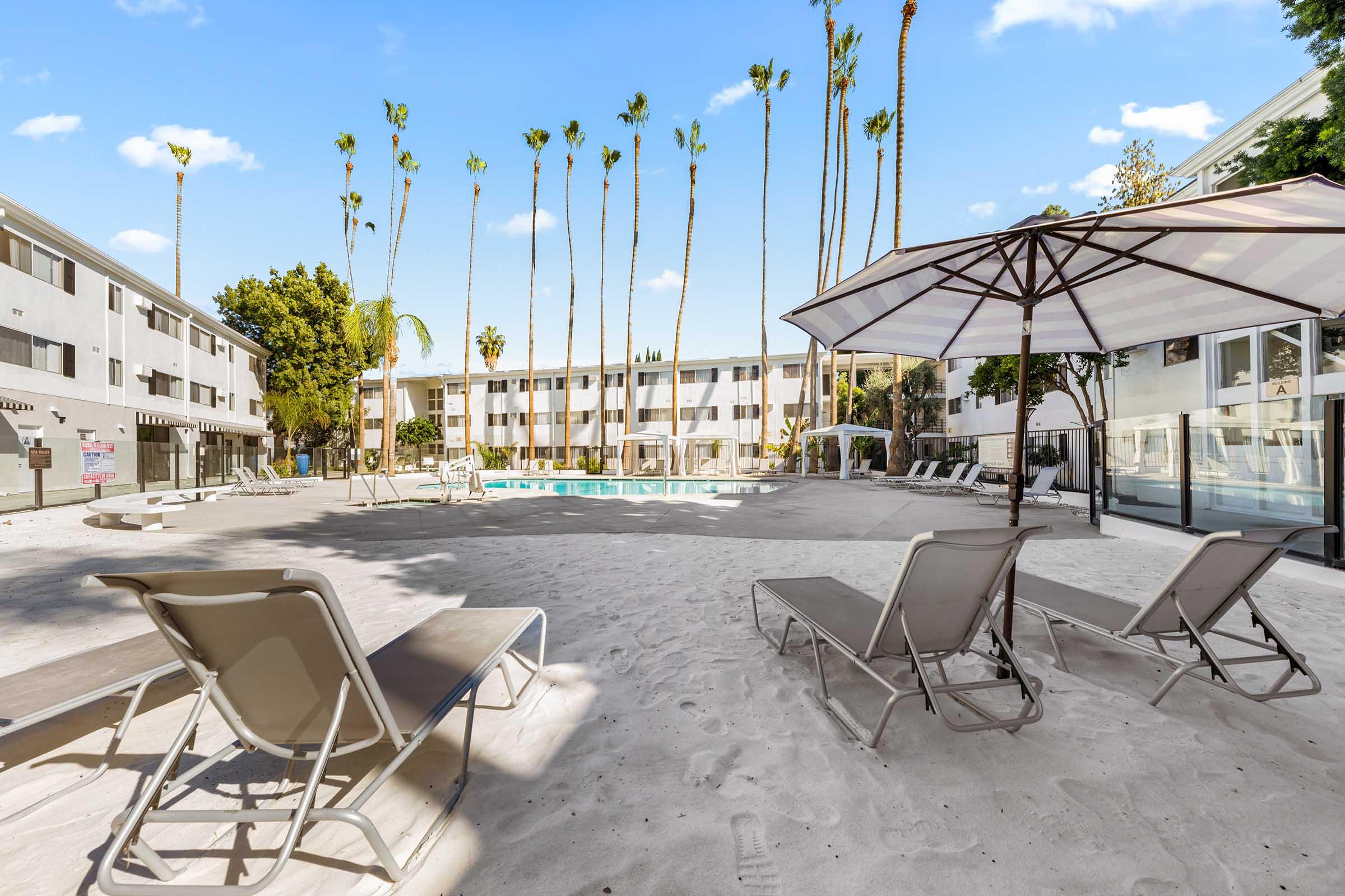 a group of lounge chairs sitting in the sand