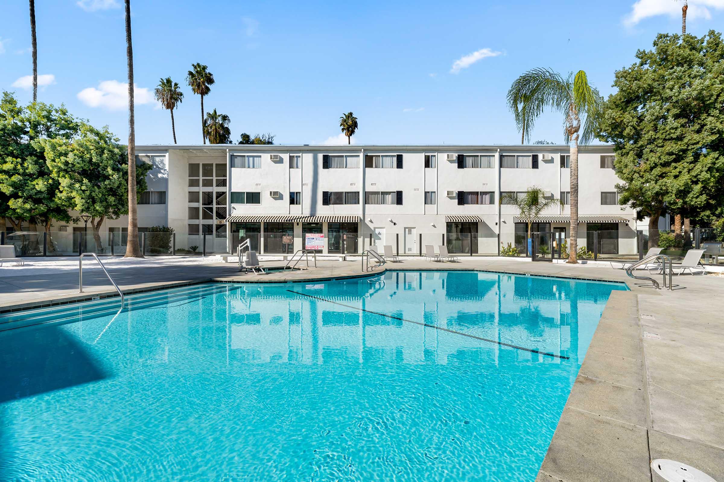 a swimming pool with a building in the background