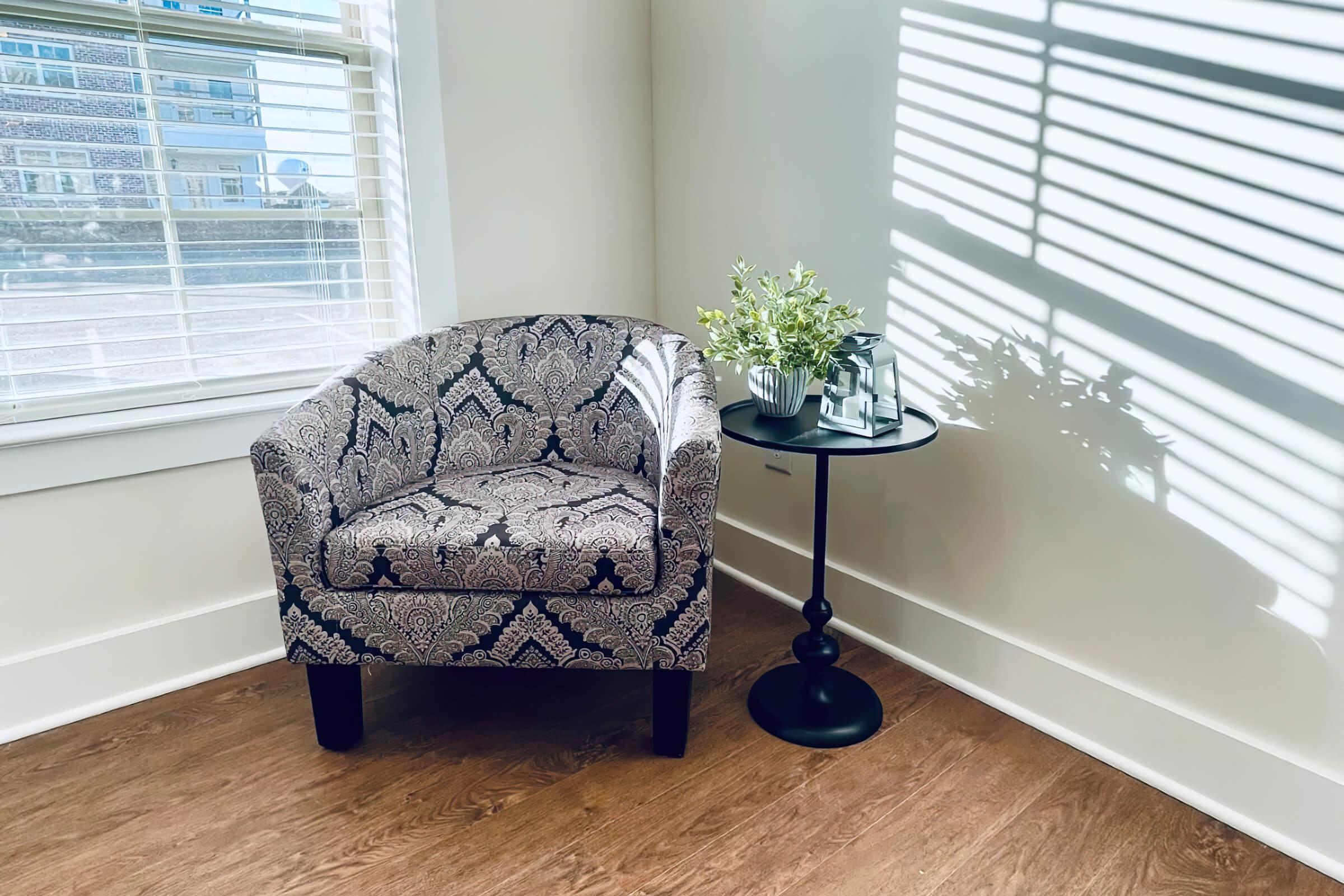 a living room filled with furniture and vase of flowers on a window