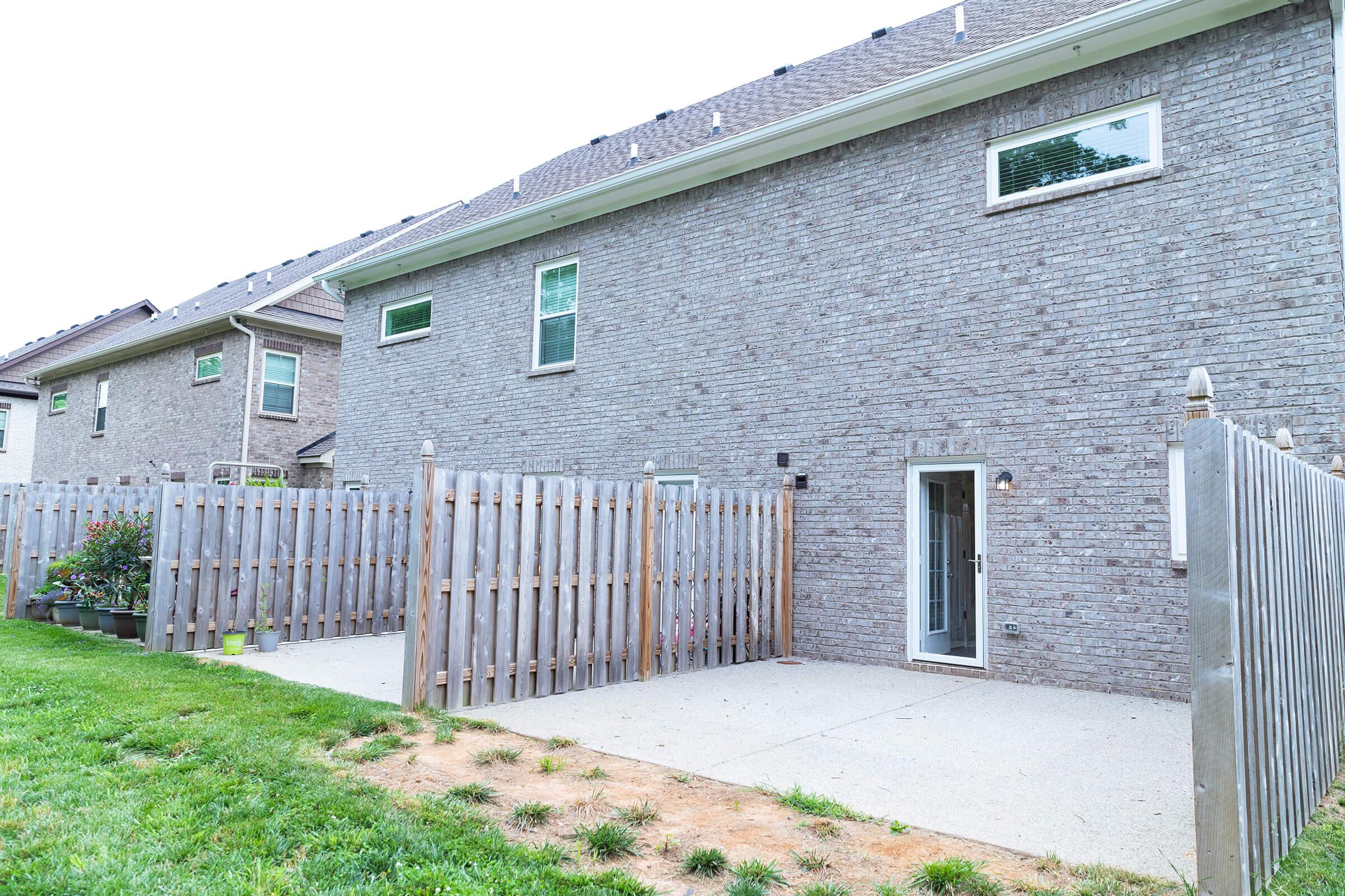 a house with a fence in front of a building